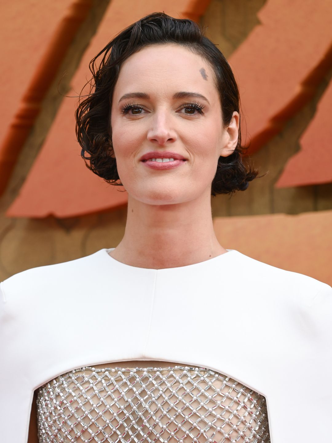 Phoebe Waller-Bridge in a shiny lattice dress with a white cape overlay at the Indiana Jones premiere 