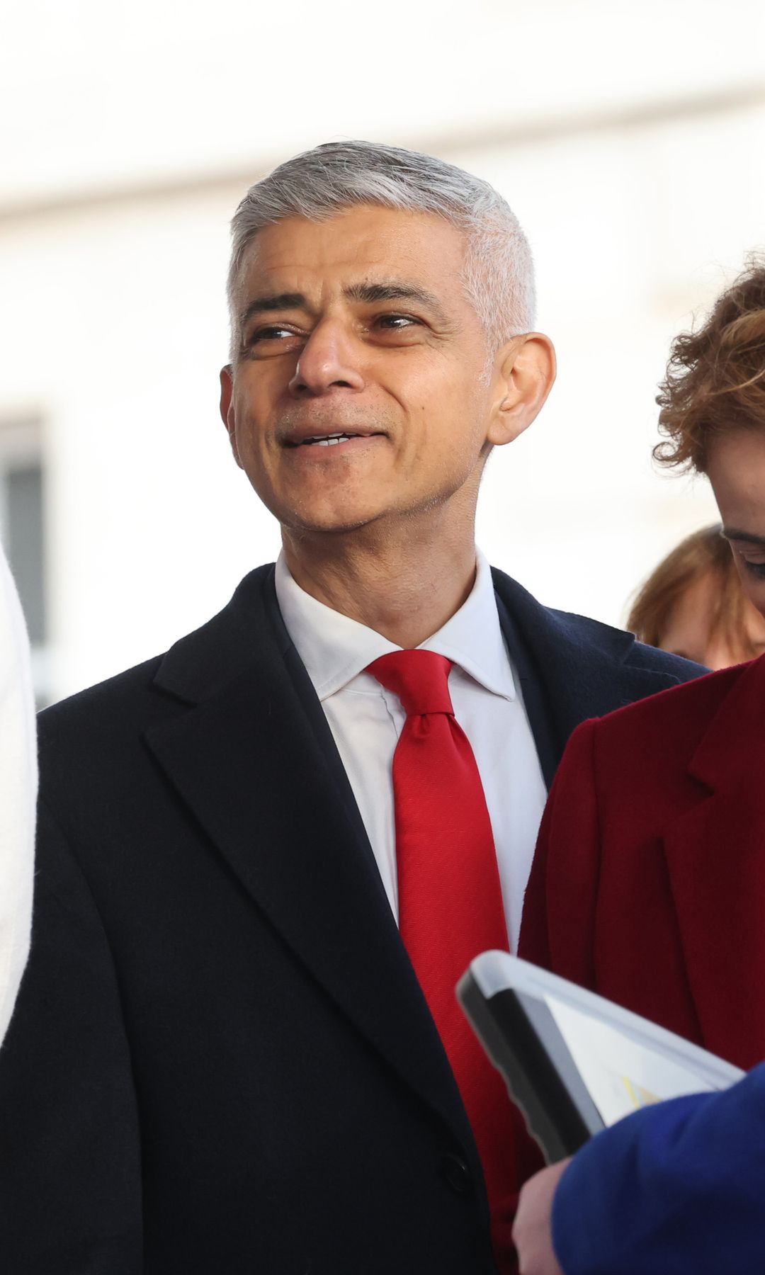 Sadiq Khan in a black suit with a red tie