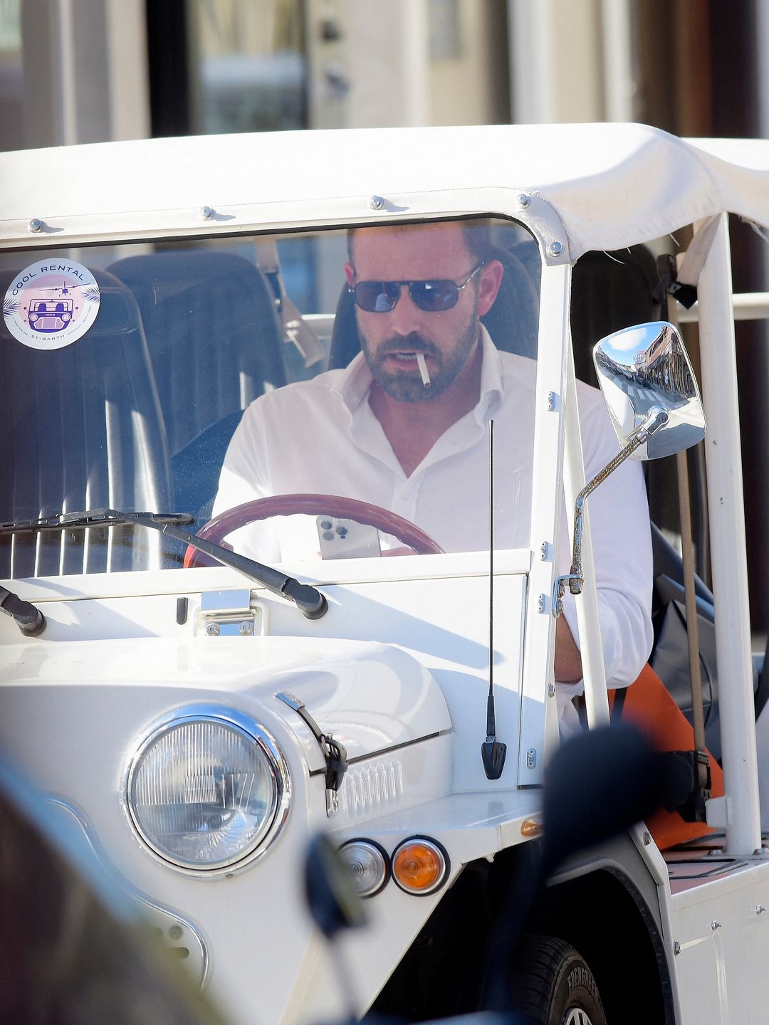 Ben Affleck enjoys a smoke as he drives a dinky Mini Moke while waiting for wife Jennifer Lopez in St Bart's