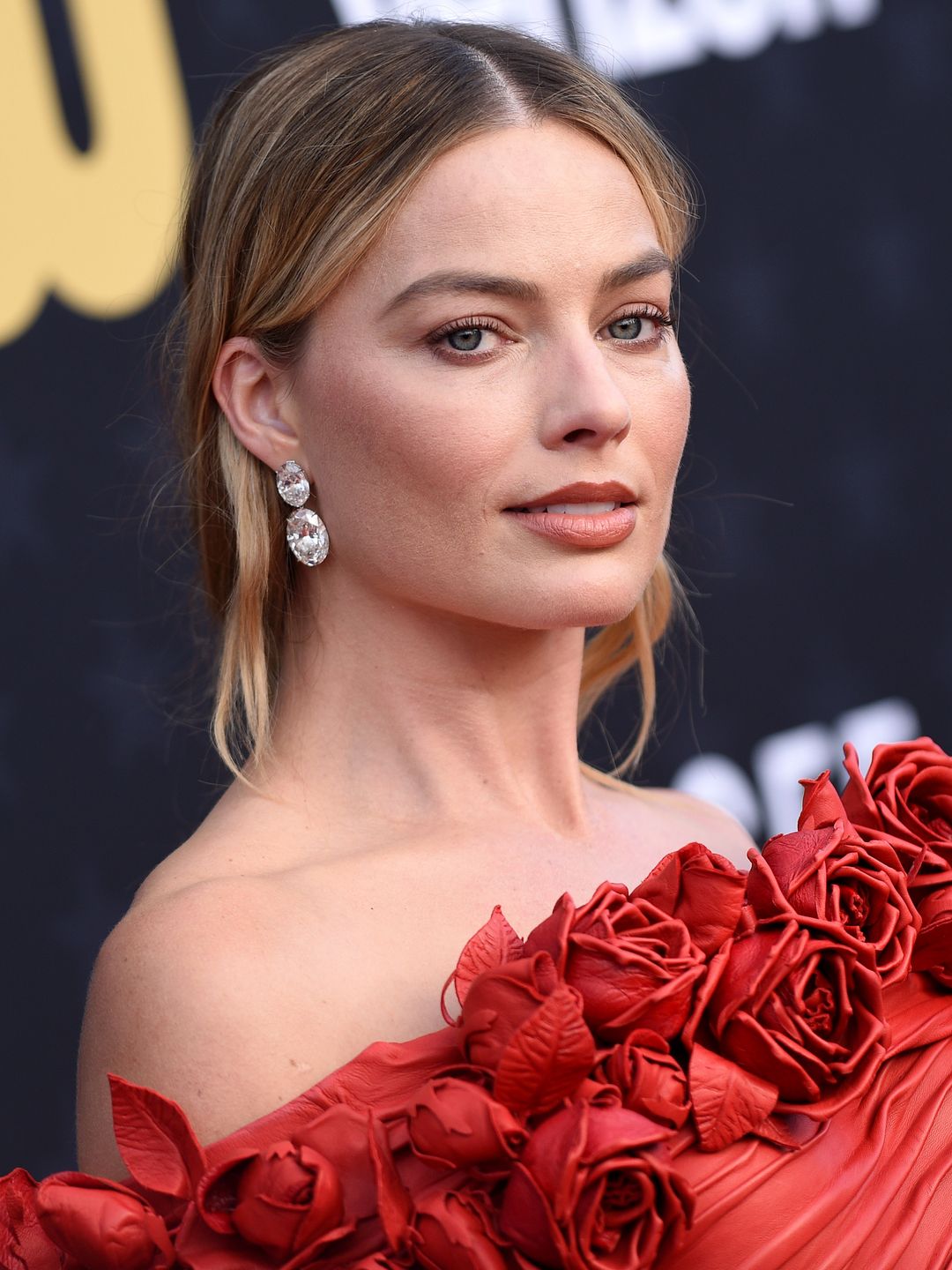 Margot Robbie wearing a gown adorned with 3D roses 