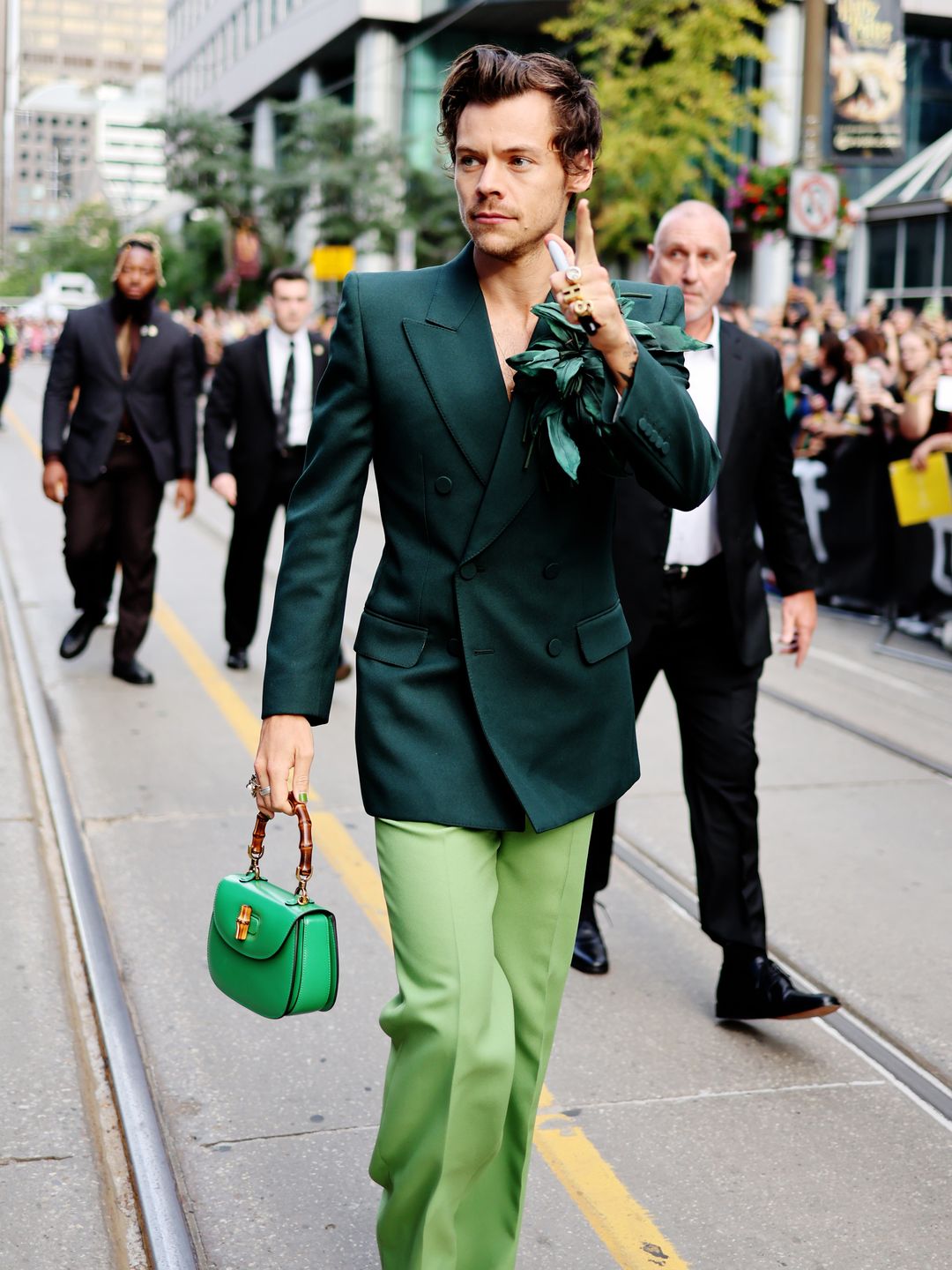 Harry Styles attends the "My Policeman" Premiere during the 2022 Toronto International Film Festival wearing a green suit and hand bag