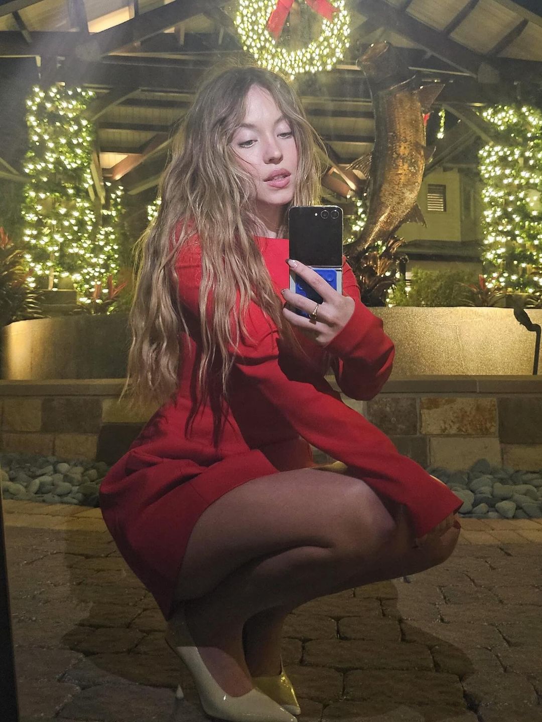 Sydney Sweeney wears a red mini dress to pose for a photo on her Instagram