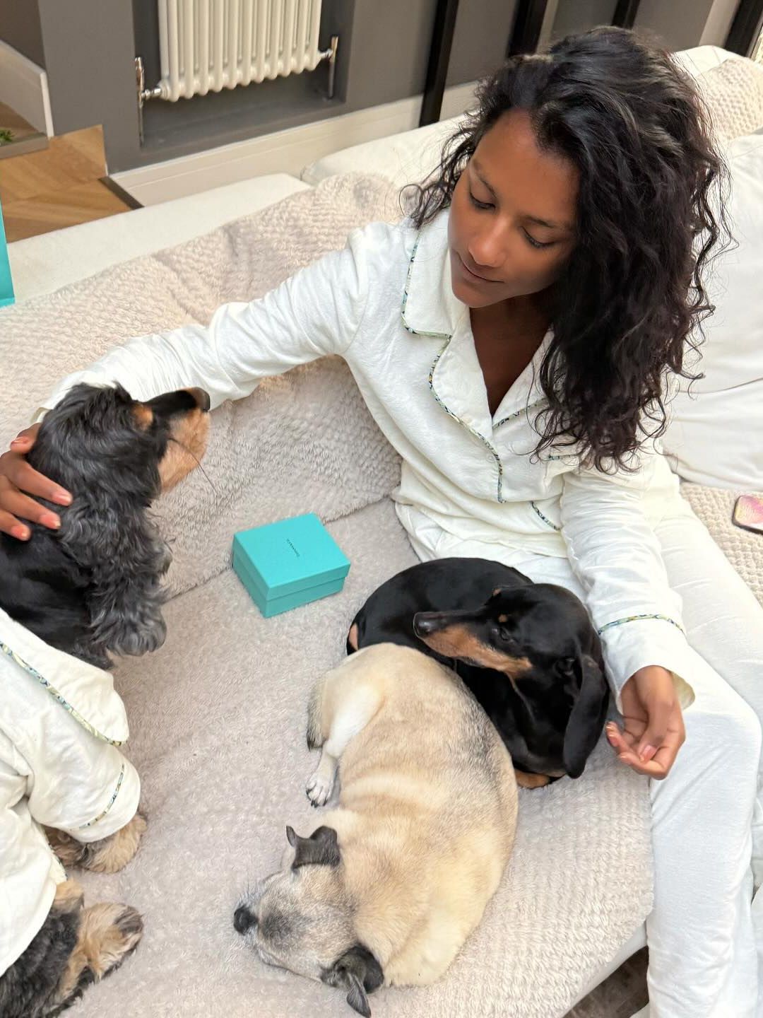 Simone Ashley poses for a photo in her pyjamas with her three dogs