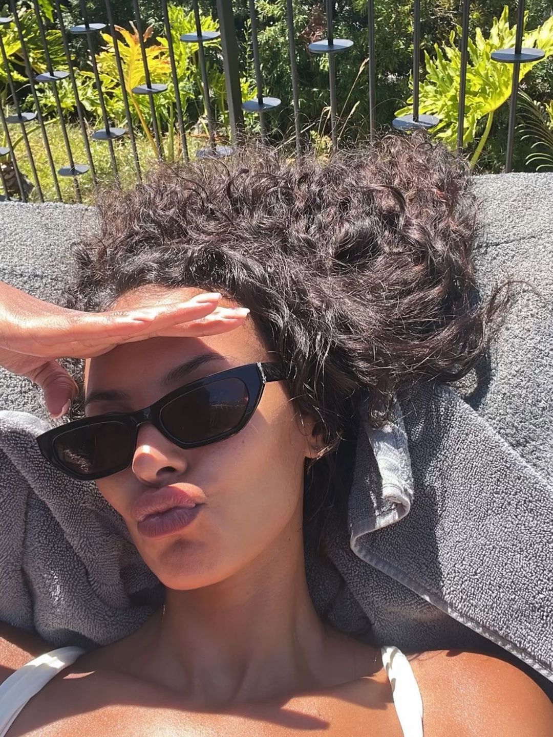 Maya Jama with natural curls by pool 