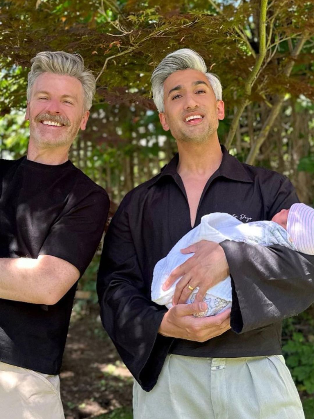 Tan France and his husband holding their two children