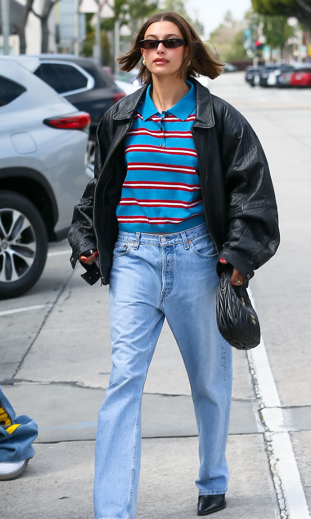 Hailey Bieber est vue le 13 mars 2023 à Los Angeles, en Californie, en jean et chemise à rayures 