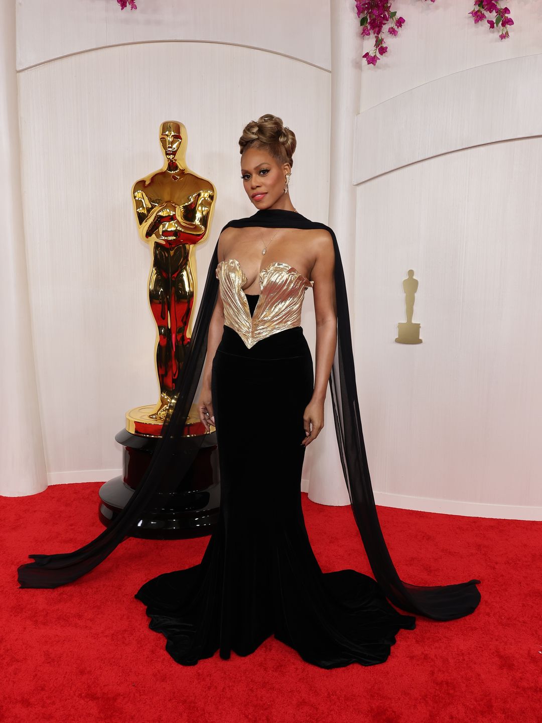 Laverne Cox attends the 96th Annual Academy Awards in a gold and black gown