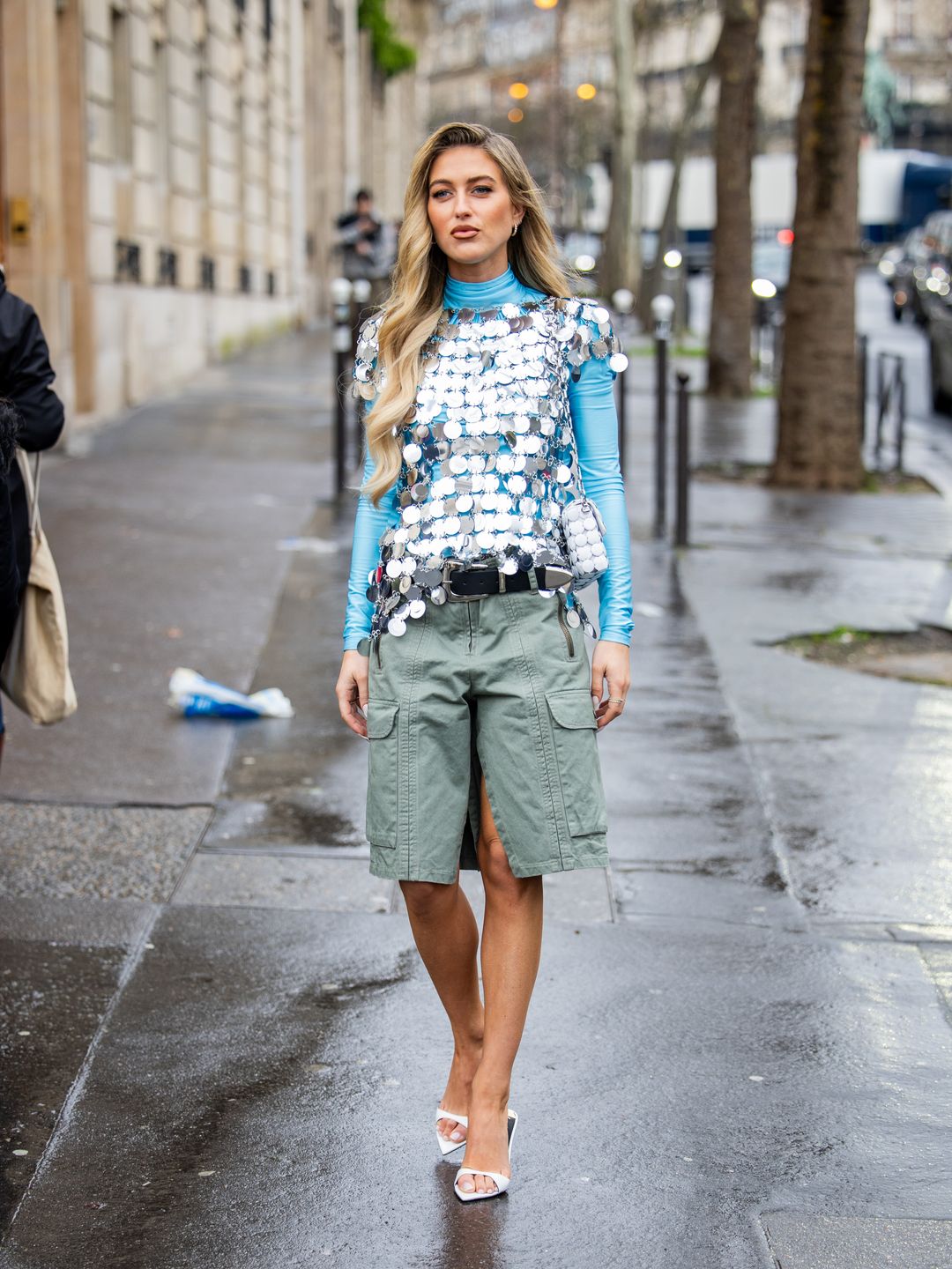 Emili Sindlev wears green shorts with side pockets, silver top, blue long shirt outside Paco Rabanne