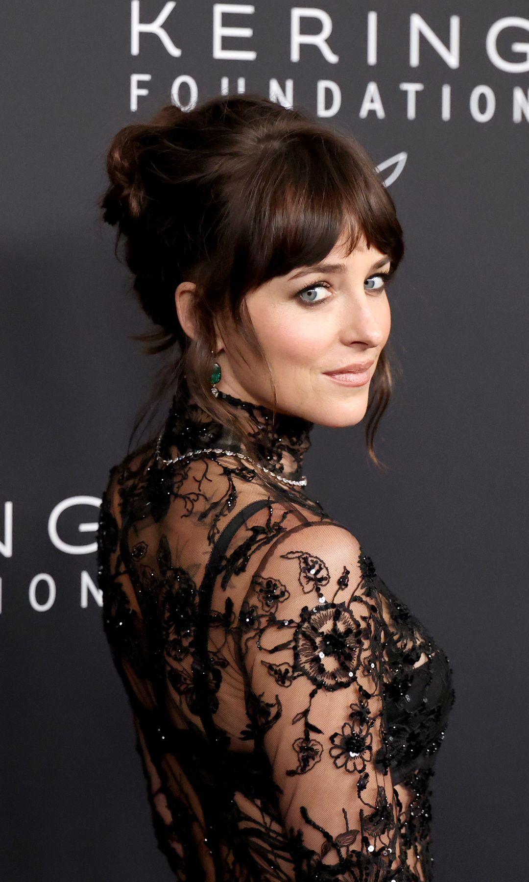Dakota Johnson in a sheer gown and high bun 