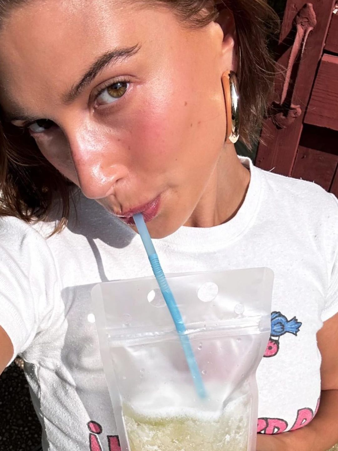 Hailey Bieber sipping a drink