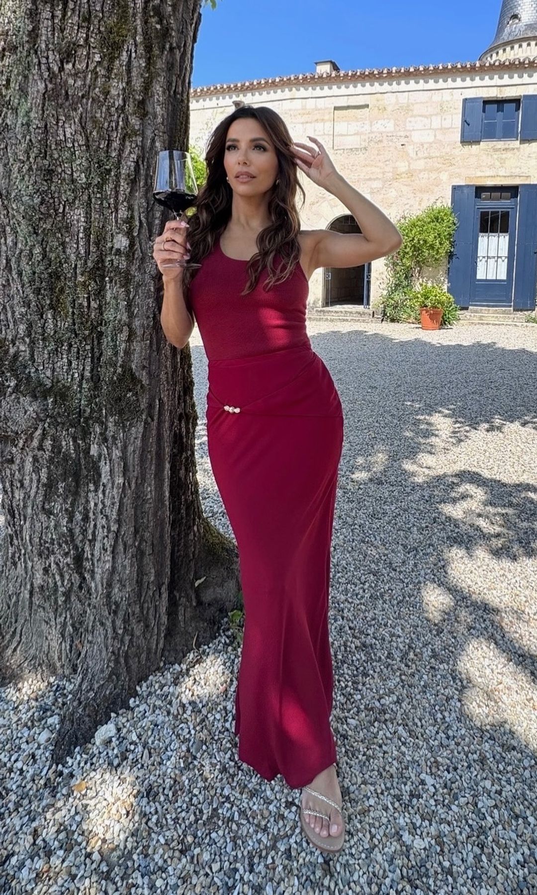 Eva Longoria poses in a red maxi dress while in France