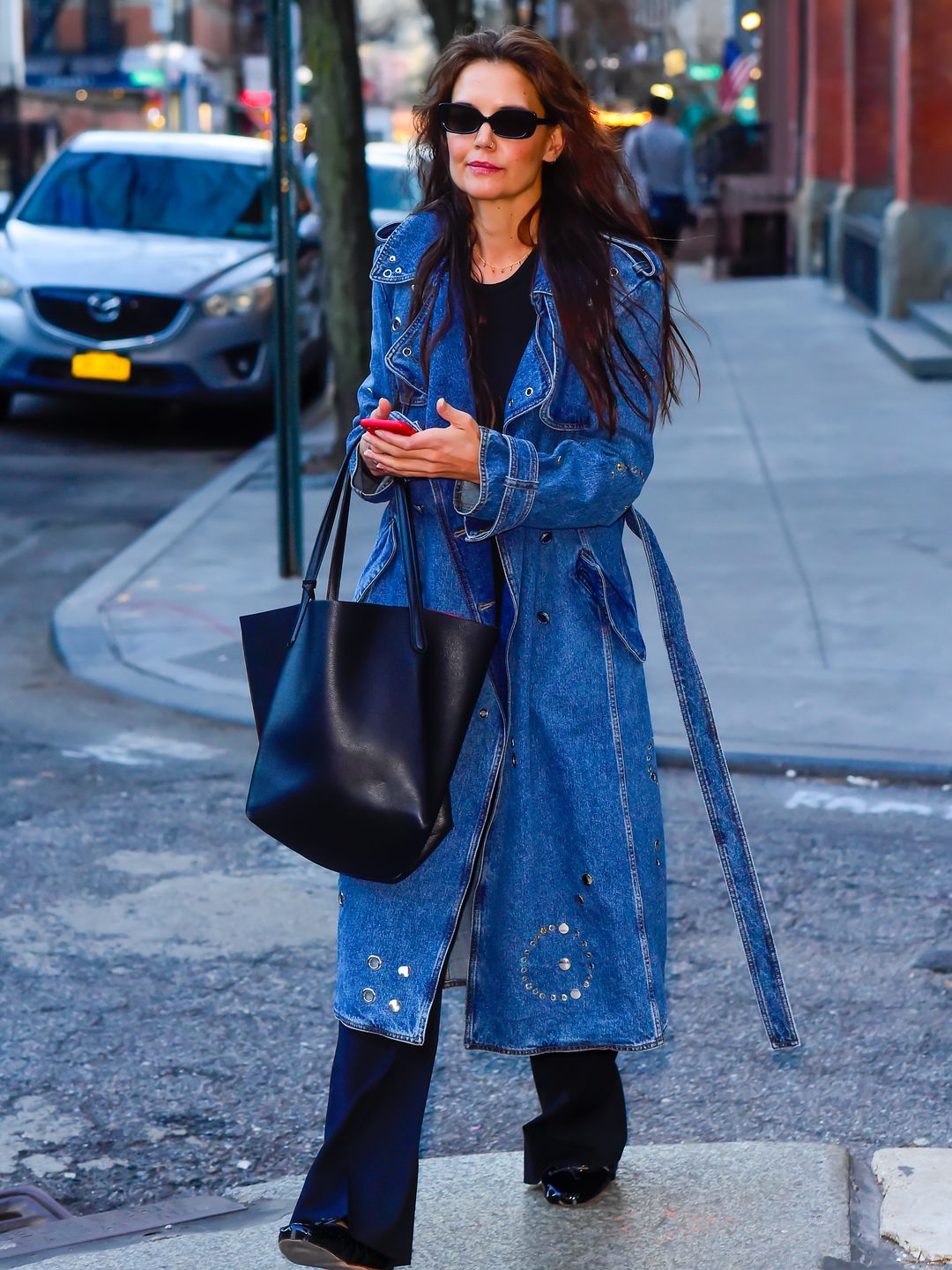 Katie Holmes is seen walking on March 25, 2024 in New York City wearing a denim trench coat