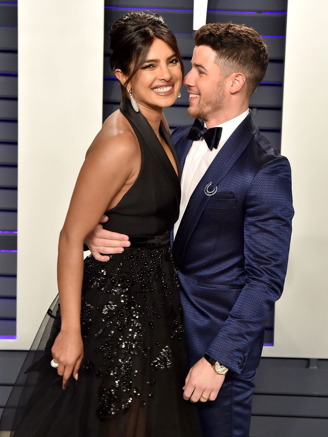 Priyanka and Nick on a red carpet together embracing and smiling