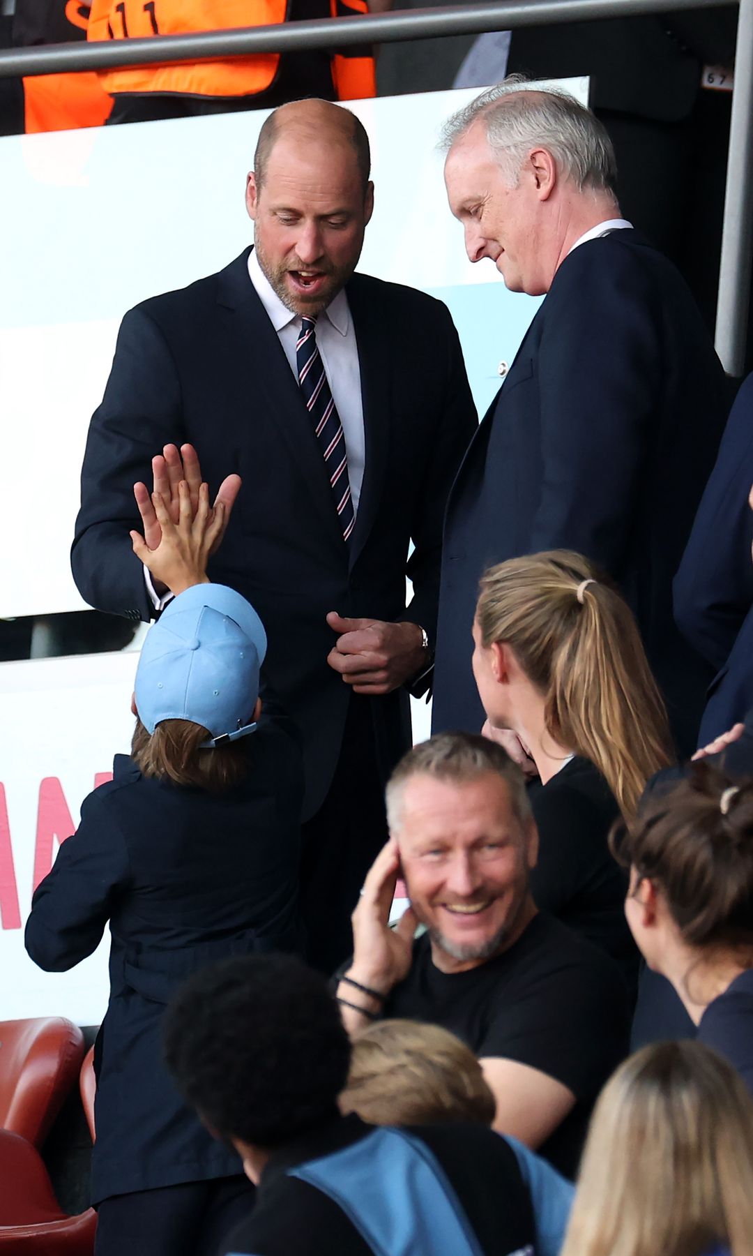 Prince William high-fiving a kid