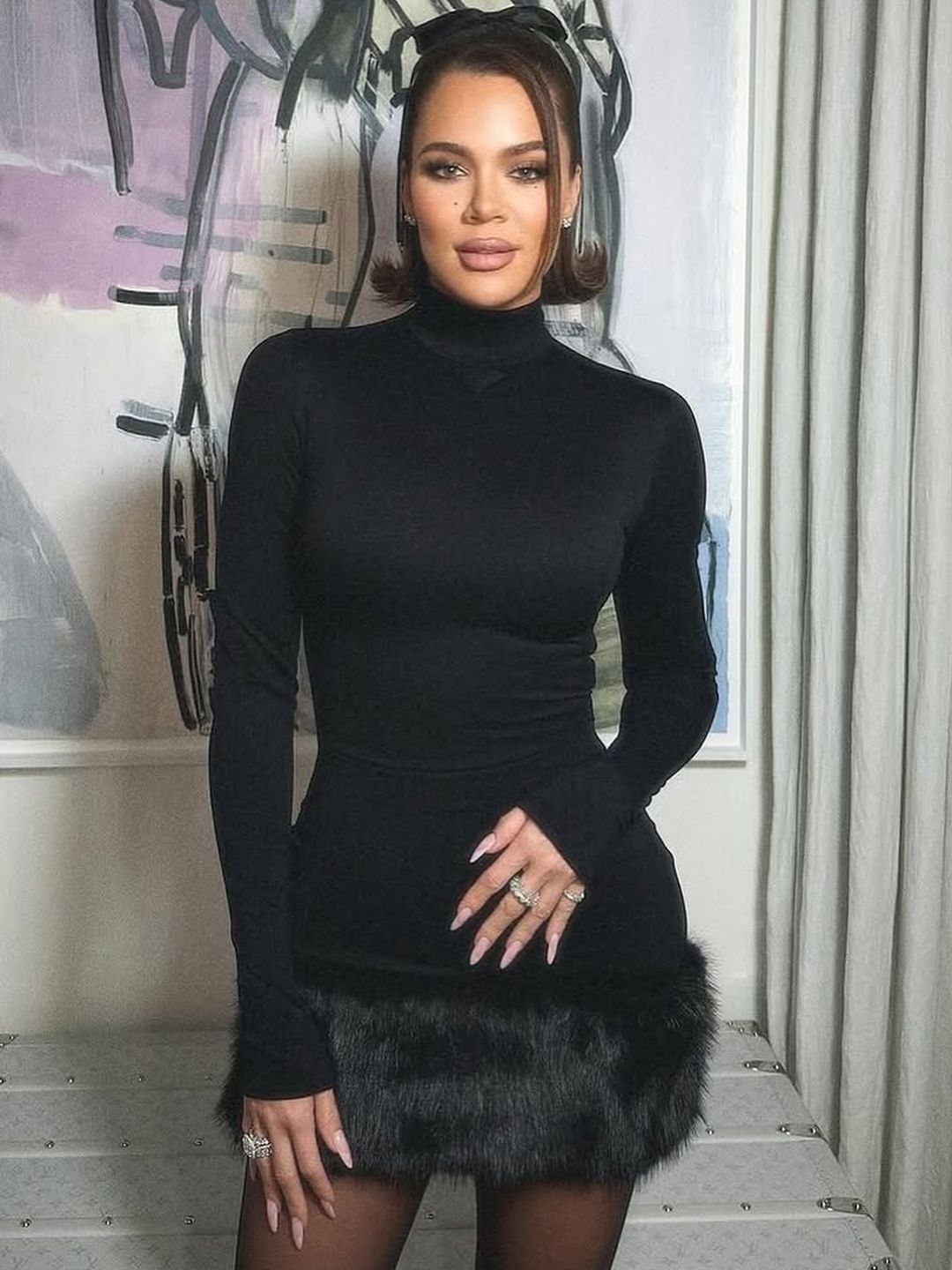 Khloe Kardashian with a monochrome outfit and pink french manicure  