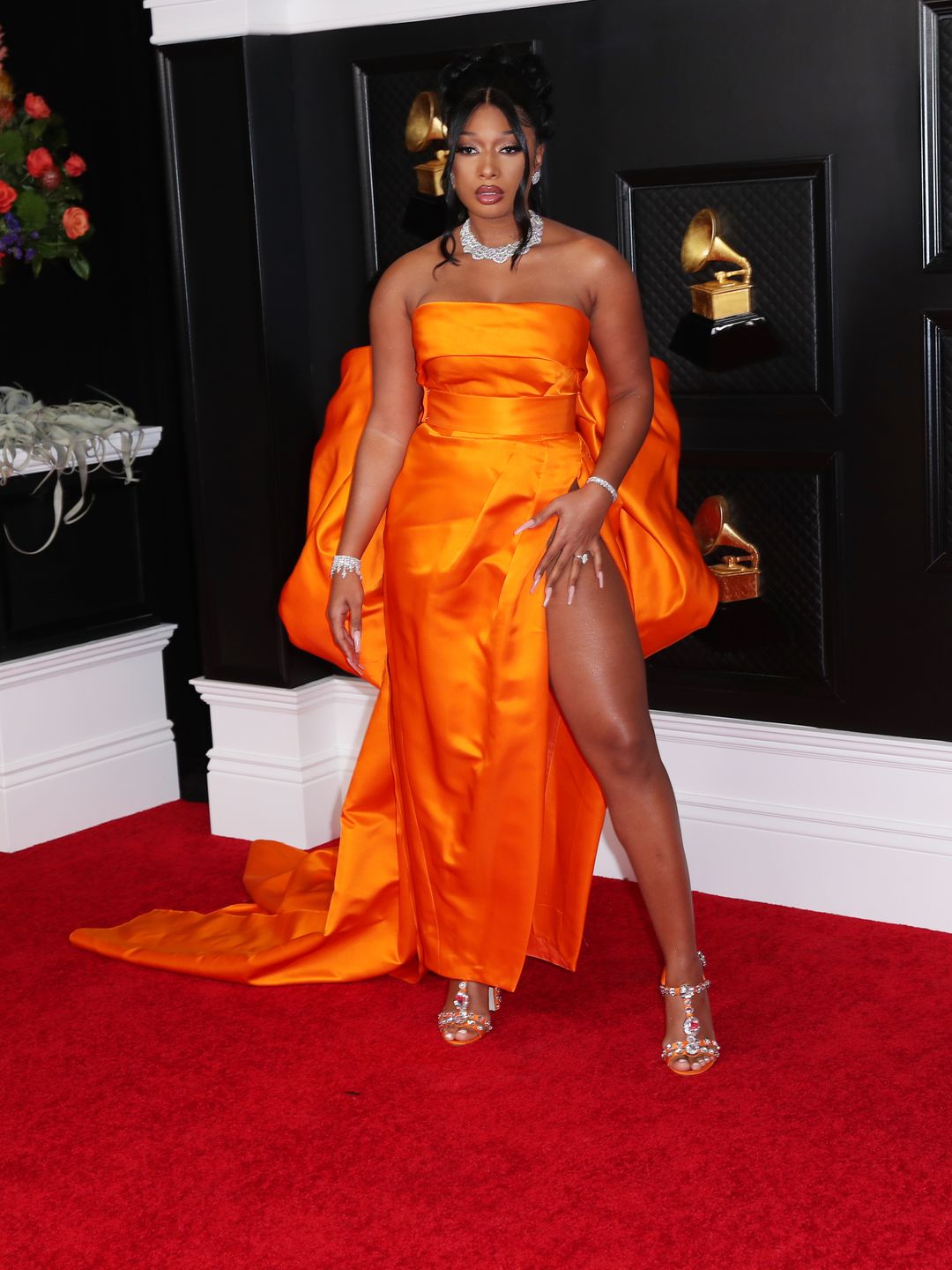 Megan Thee Stallion wears a bright orange gown and diamond jewellery at the Grammy Awards 2021