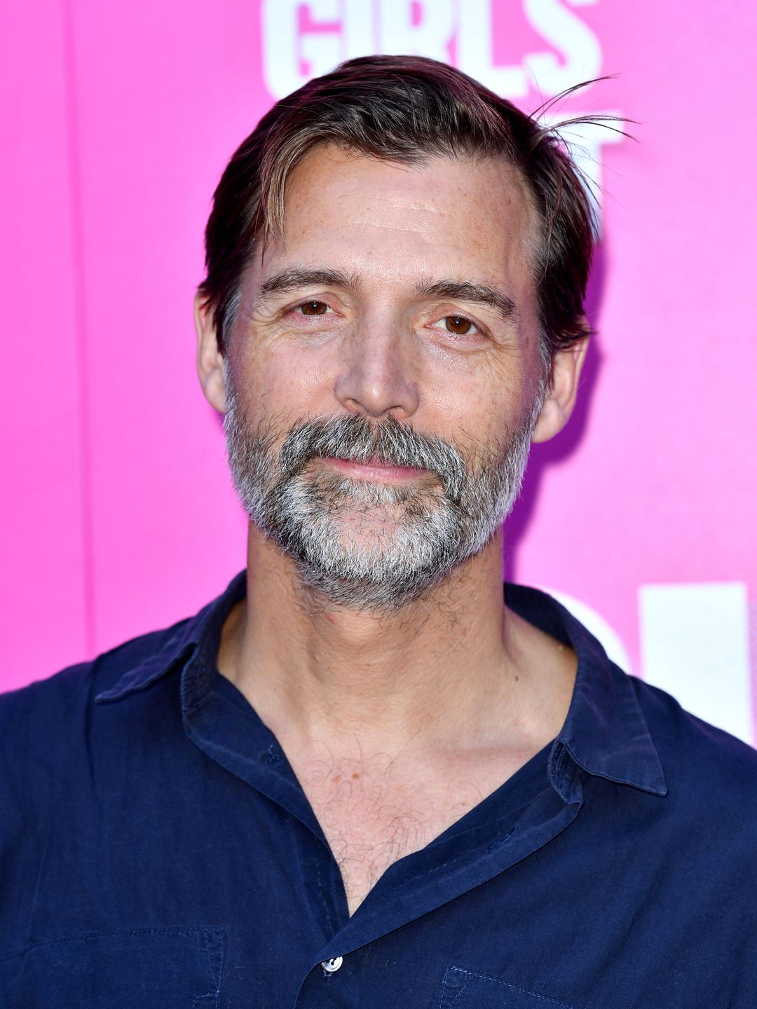 Close up of Patrick Grant smiling in a navy shirt
