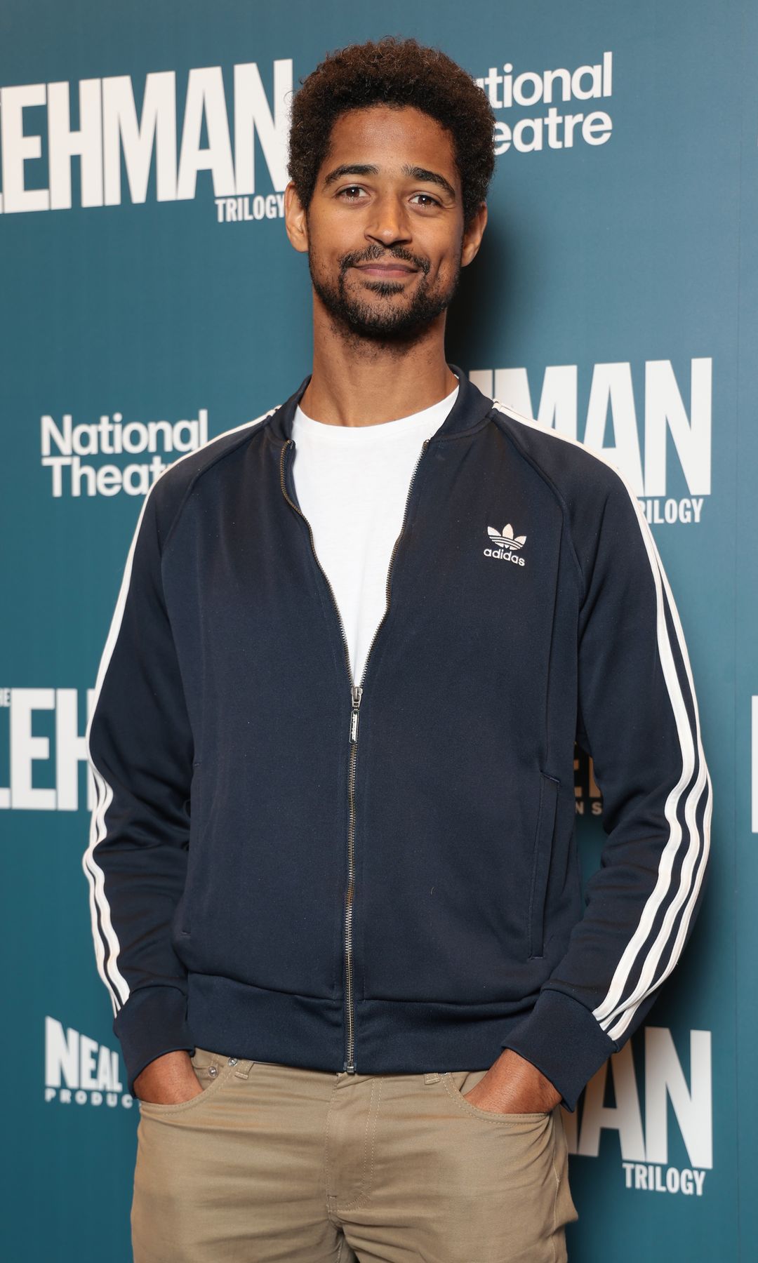 Alfred Enoch in a sports jacket and jeans