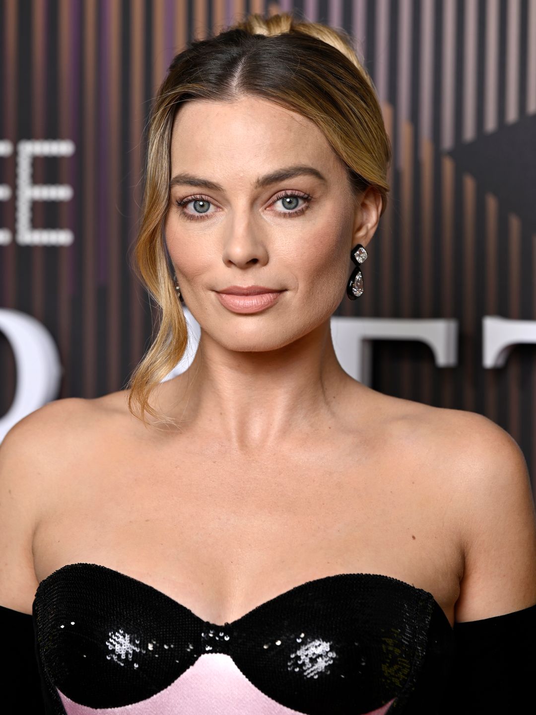 Margot Robbie wearing a black and pink strapless gown at the BAFTAs 