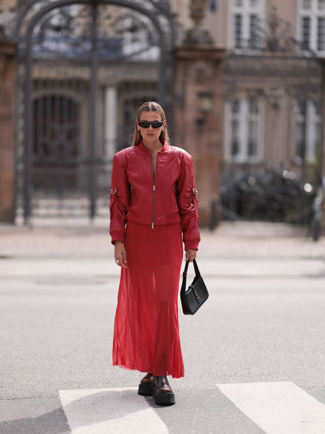 Alessa Winter wearing top to toe red in varying textures plus a Saint Laurent bag. 