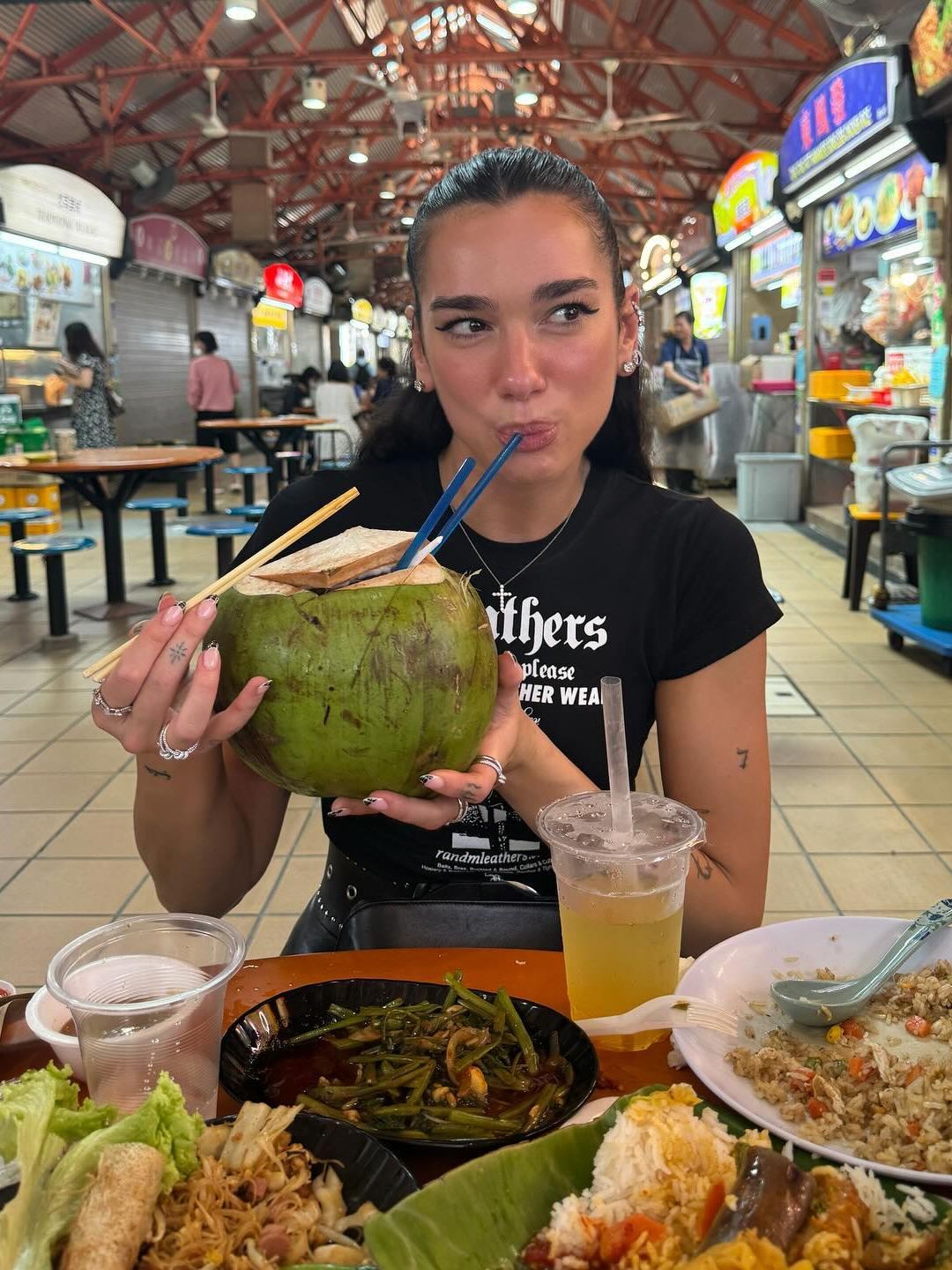 Dua Lipa sips on a coconut while in Singapore