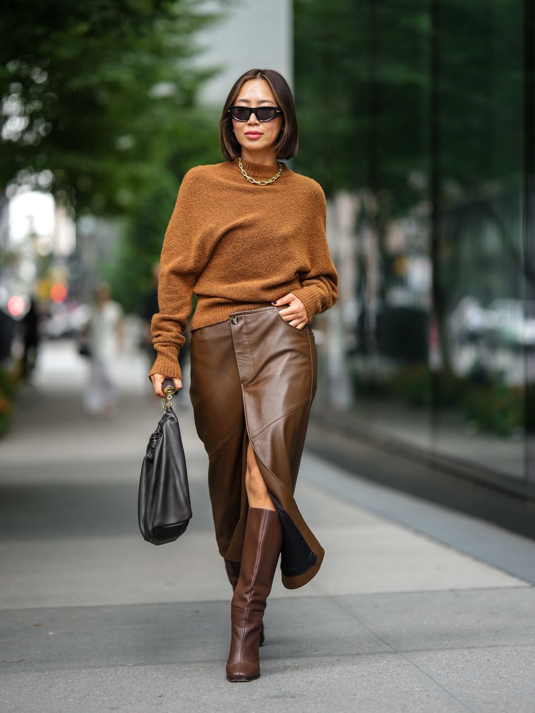 Woman wearing chocolate brown leather midi skirt with tan knit 