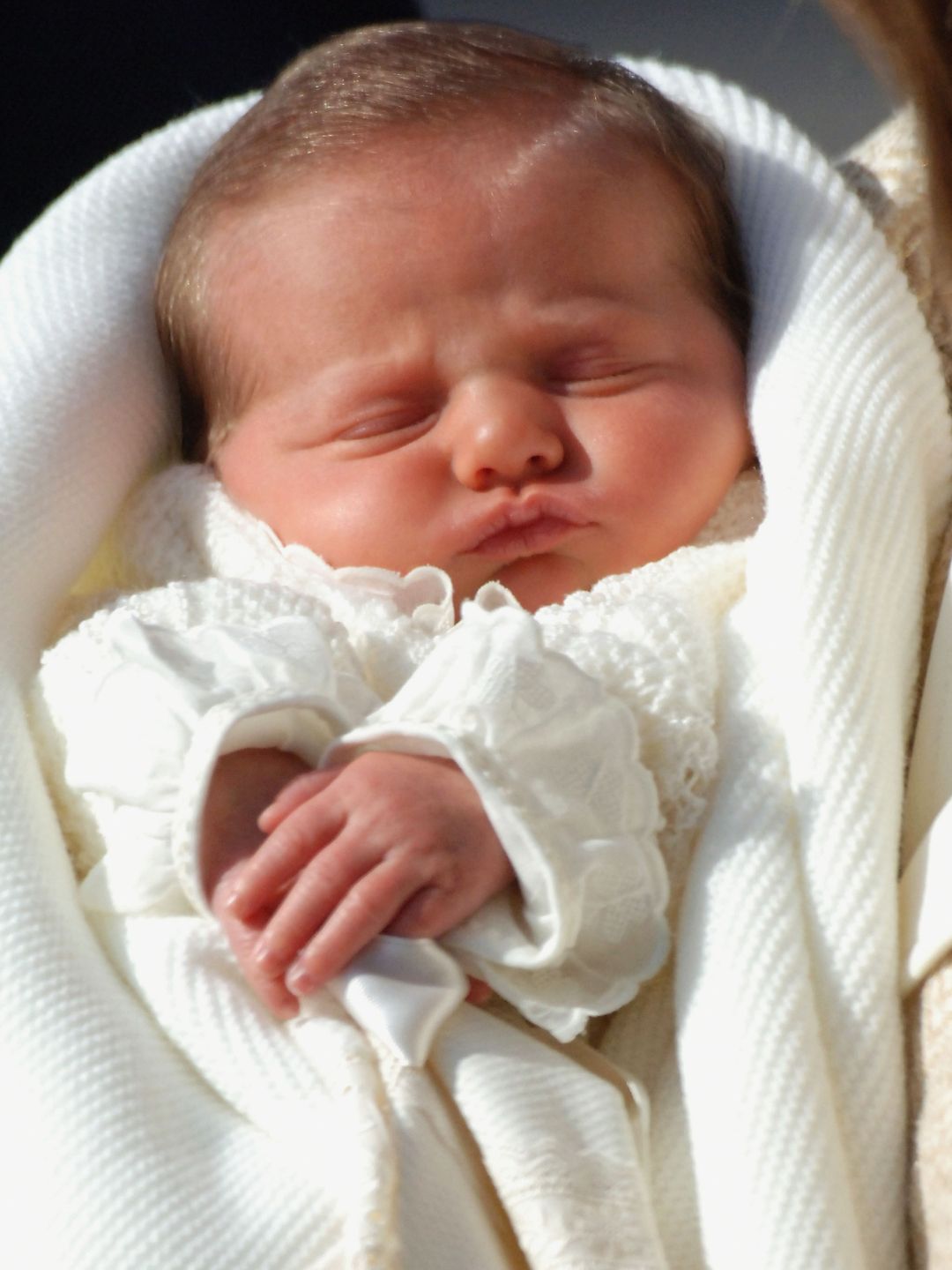 A baby swaddled in a white blanket