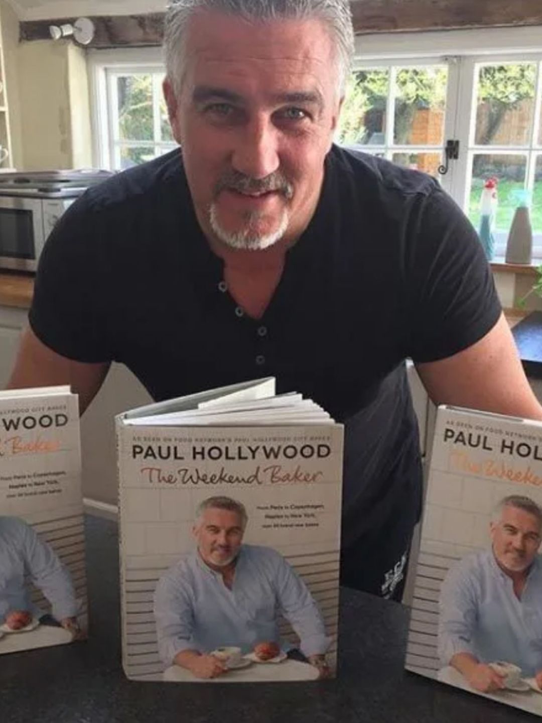 Paul Hollywood in a kitchen in front of three books