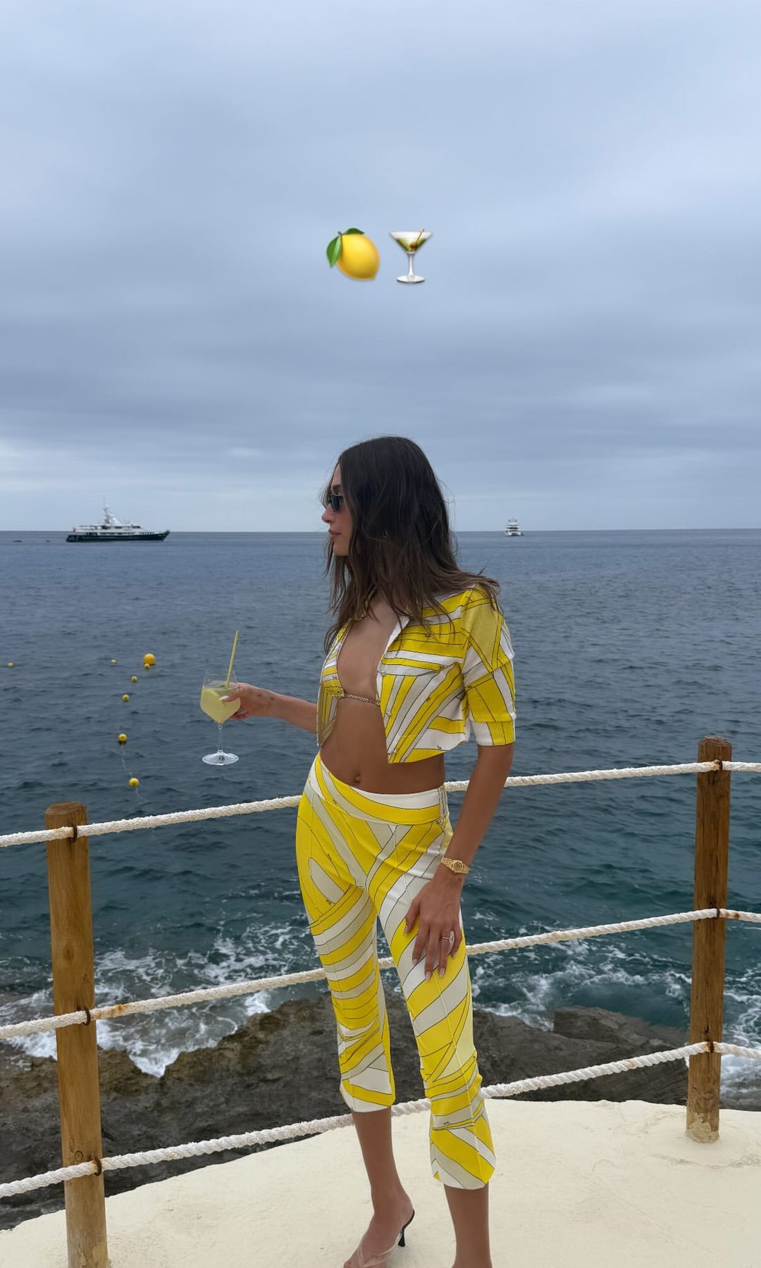 Hailey Bieber poses in yellow capri pants, a matching bikini top and shirt in Italy