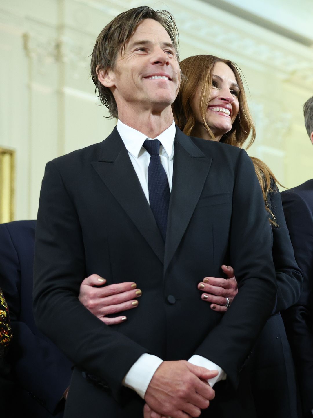 Julia Roberts smiling and hugging a smiling Daniel Moder from behind