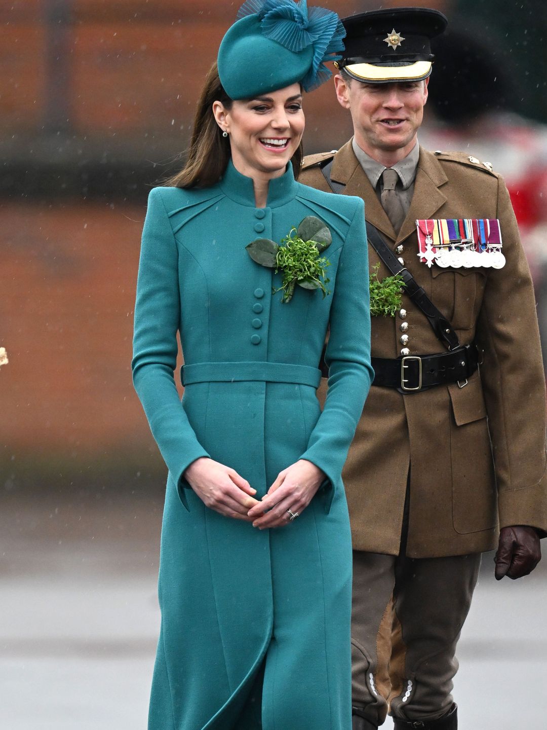 Princess Kate smiling in a teal hat and dress