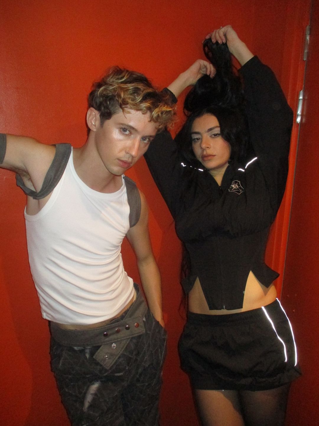 Charli XCX and Troye Sivan pose for a picture backstage