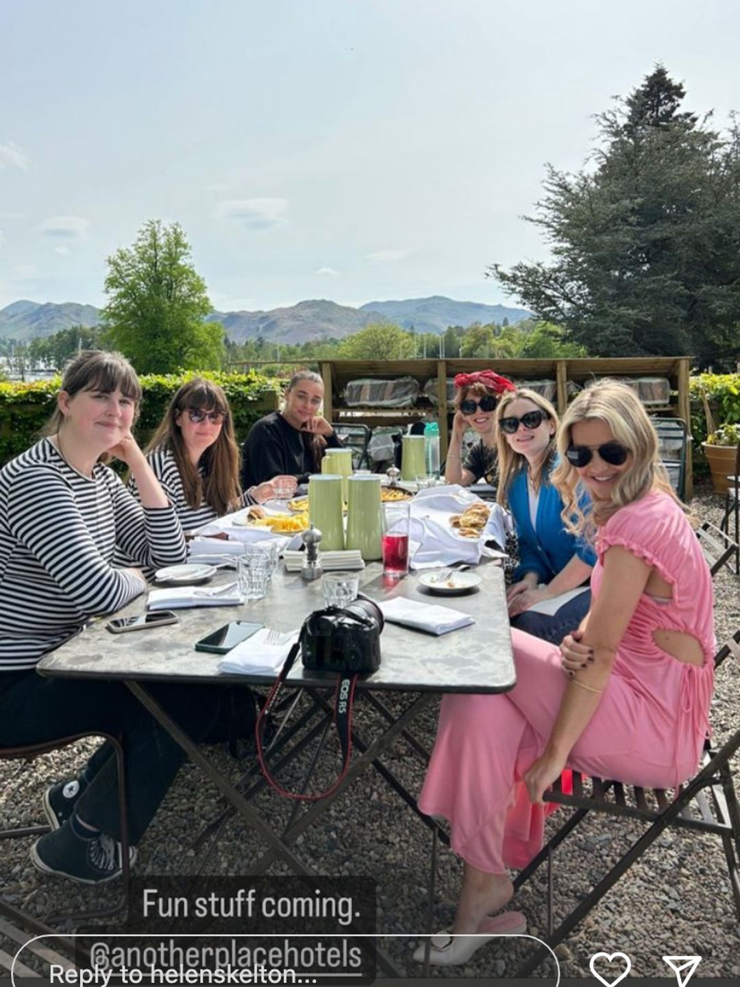 Helen enjoying lunch in the sunshine with friends. She is wearing a pink summer dress. 