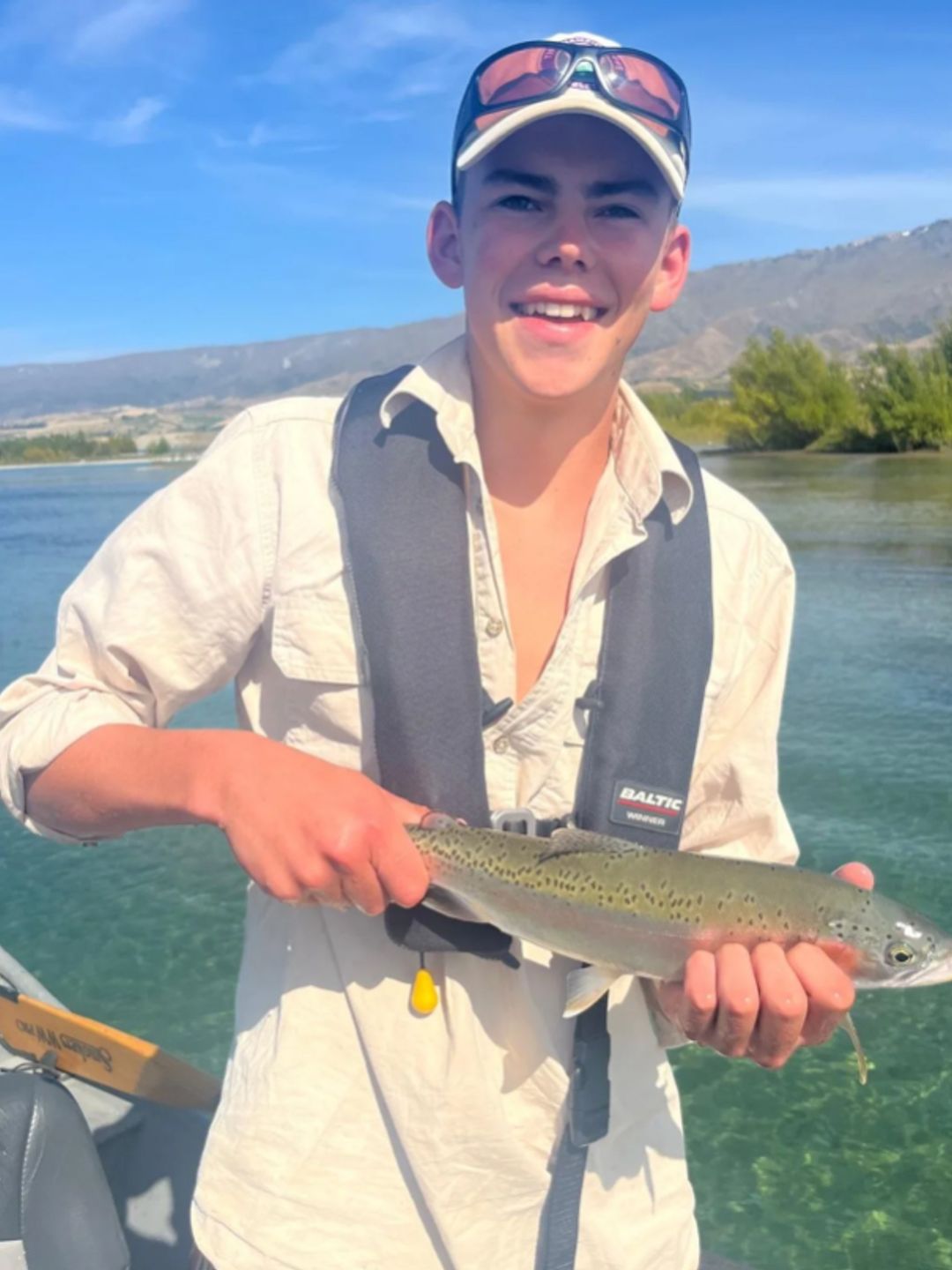 A teenage boy holding a fish