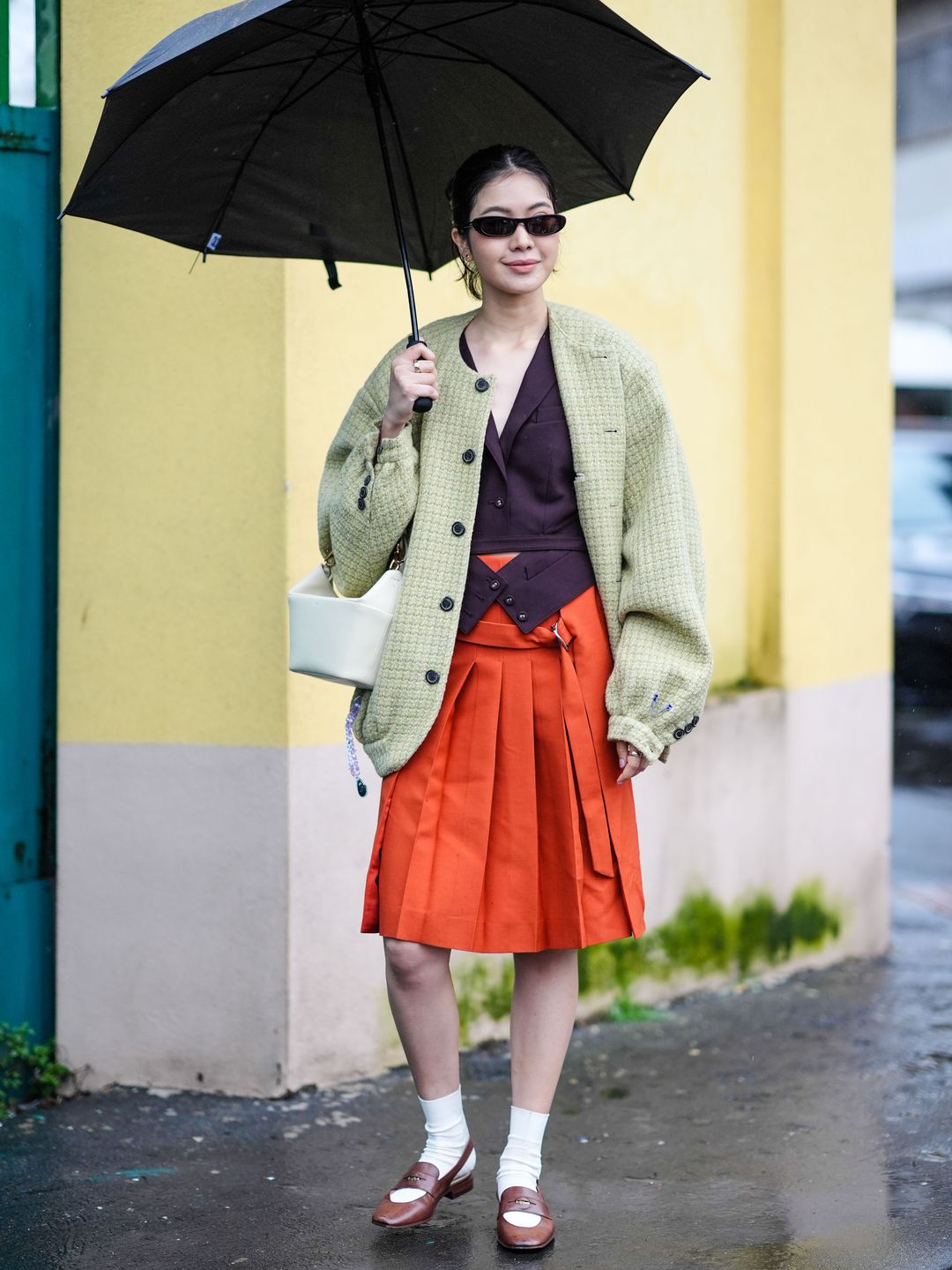 A flawless combination of knee length skirt, waistcoat, oversized jacket and loafers. 