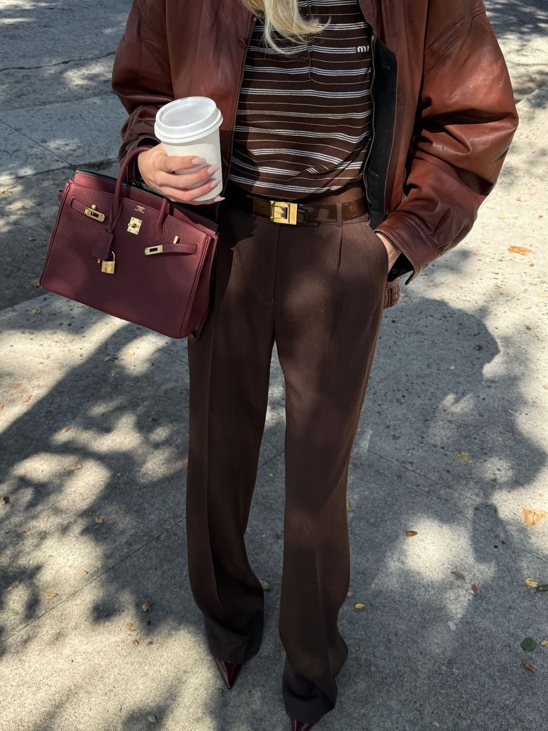 Elsa Hosk poses in brown trousers, a striped shirt and leather jacket on her instagram