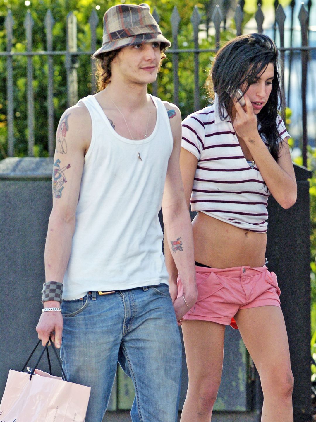 Amy Winehouse and her boyfriend at the time Blake Fielder-Civil walking in the park. Amy wears a striped t-shirt and hot pink mini shirts 