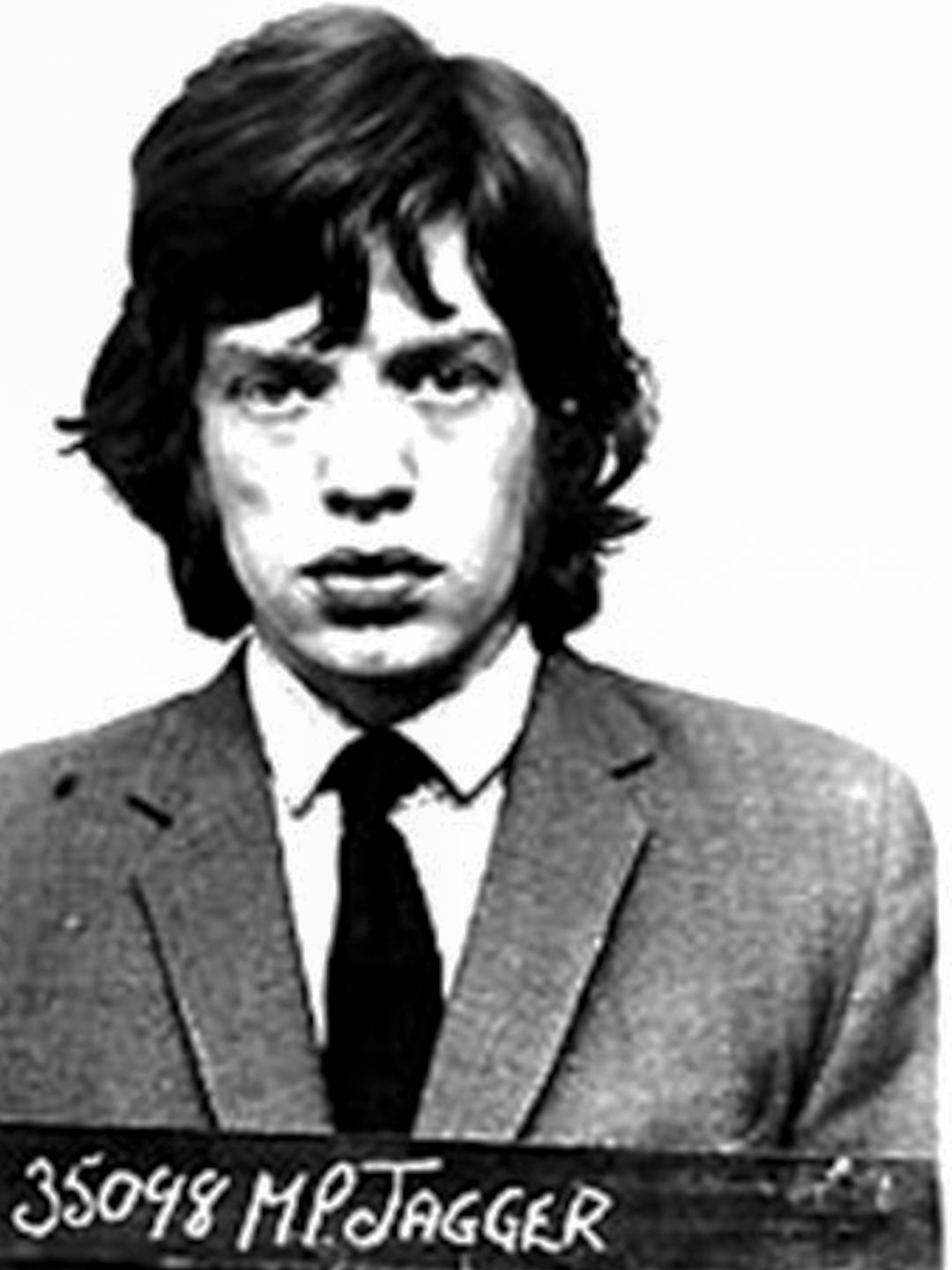 Black-and-white phot of Mick Jagger's mugshot, he wears a suit and tie