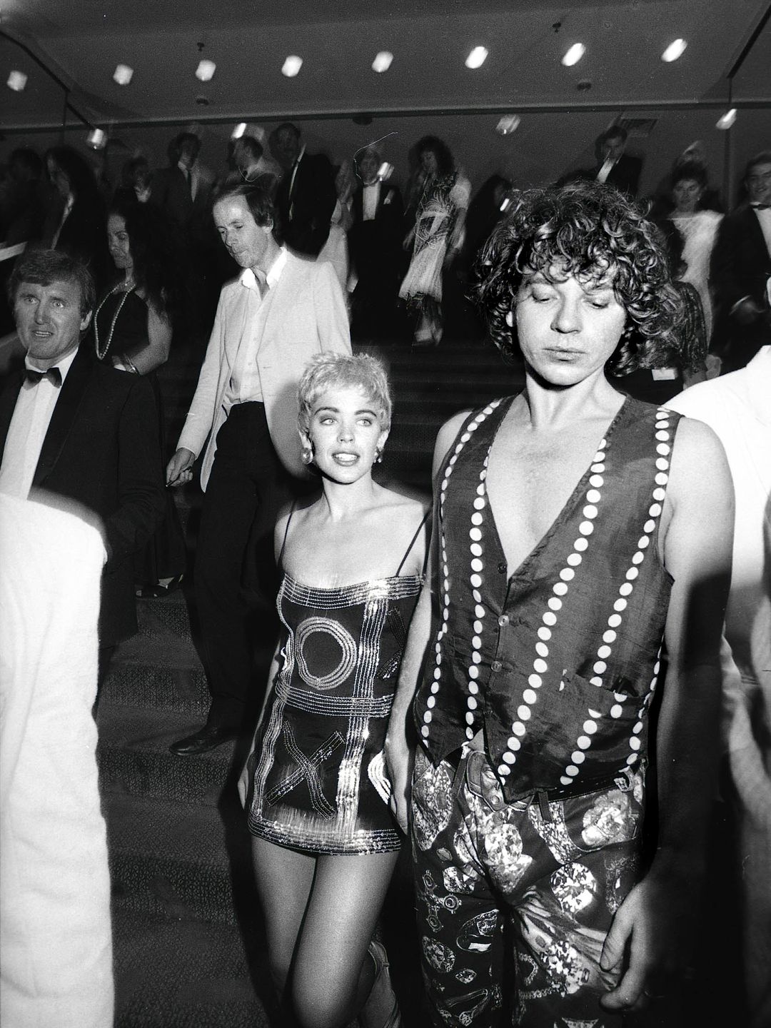 Kylie Minogue wearing a sparkly mini dress and holding hands with Michael Hutchence 