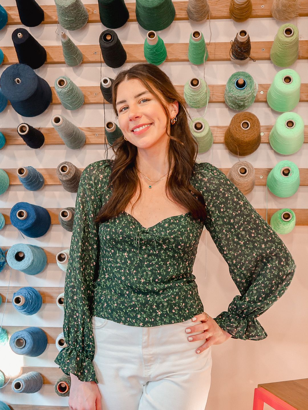 Layla Sargent, founder of The Seam posing in front of yarns of cotton