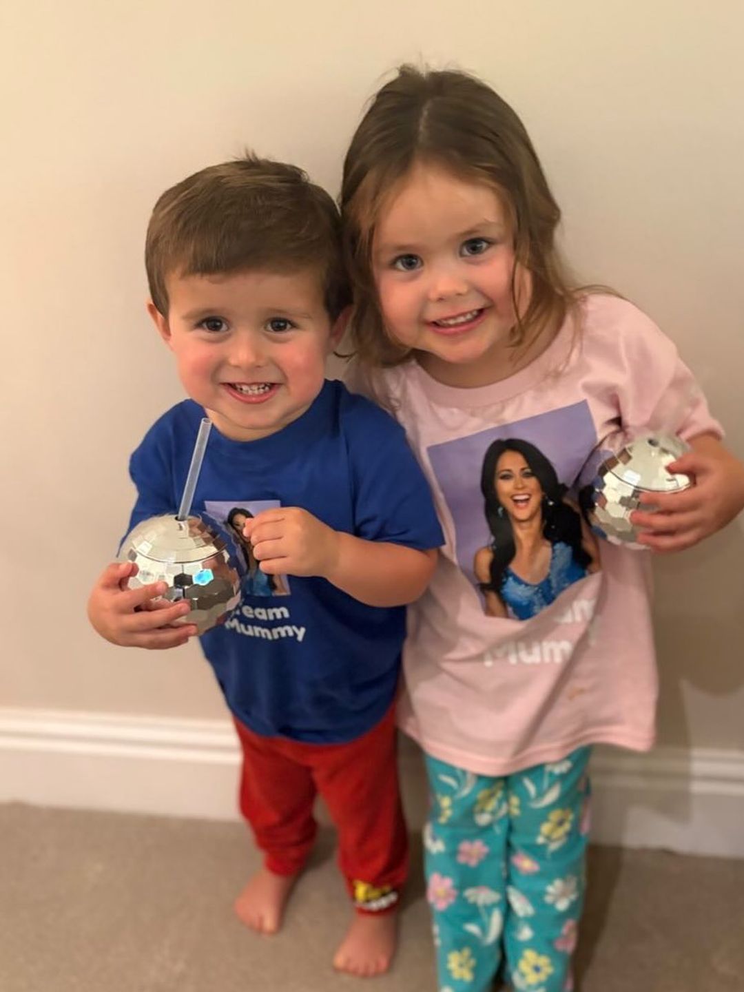 brother and sister smiling with sparkly cups 