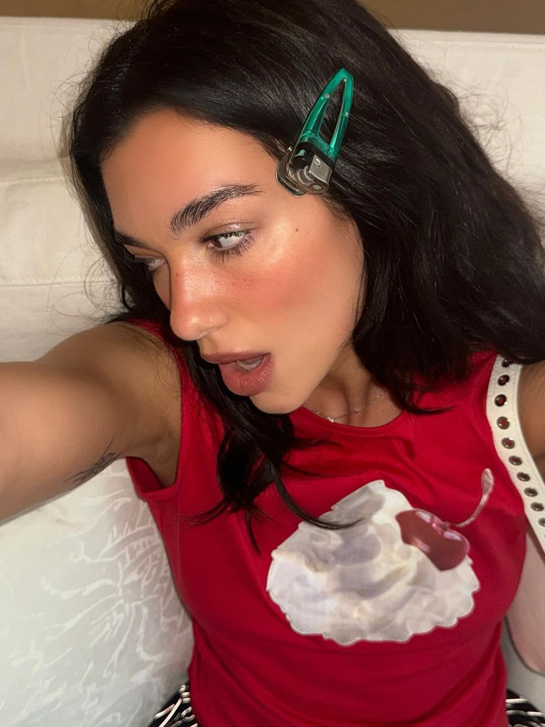 Dua Lipa poses ofr a selfie in a red tank top on her Instagram