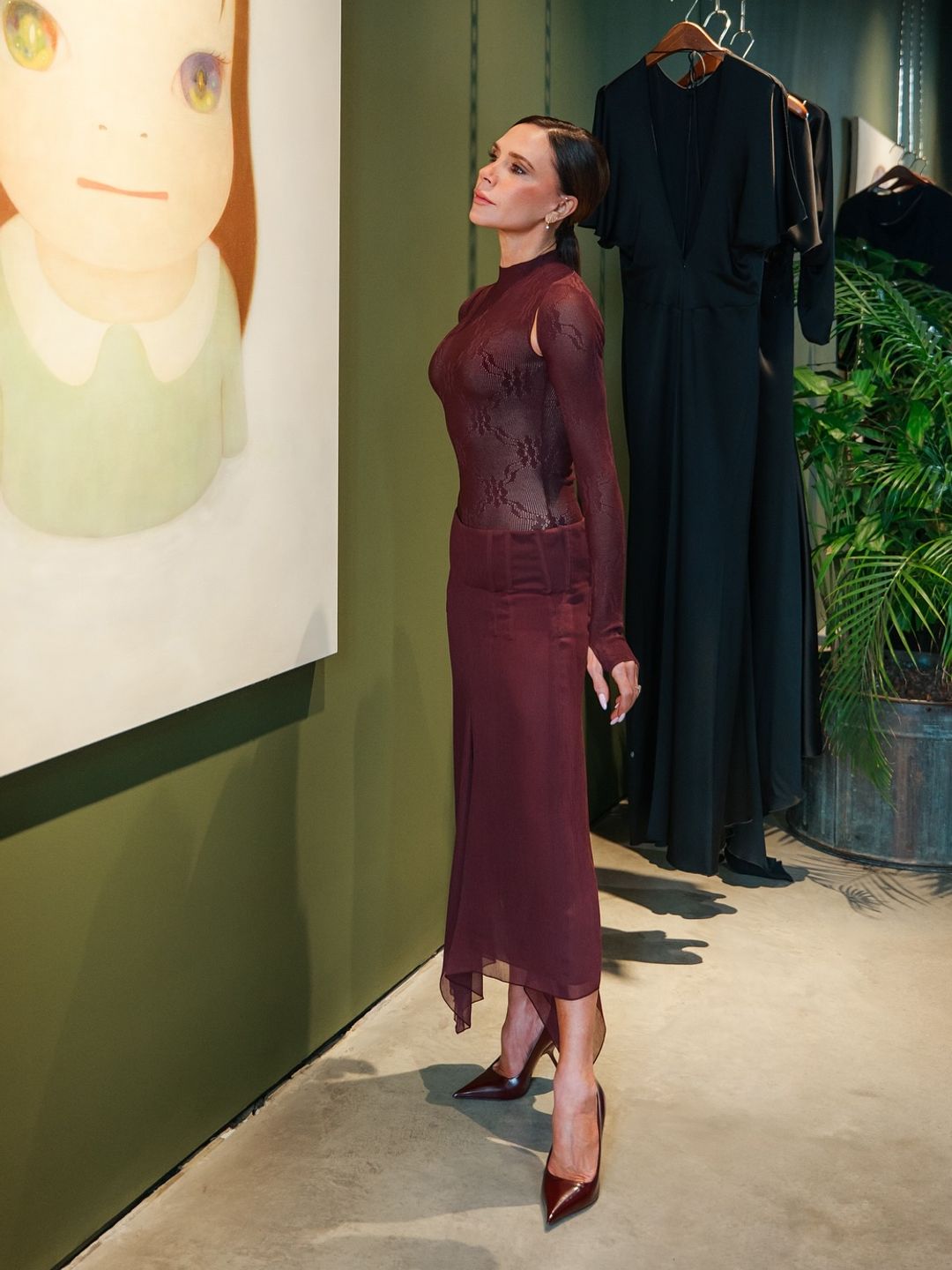 Victoria Beckham berpose dalam pakaian merah anggur di toko Dover Street -nya