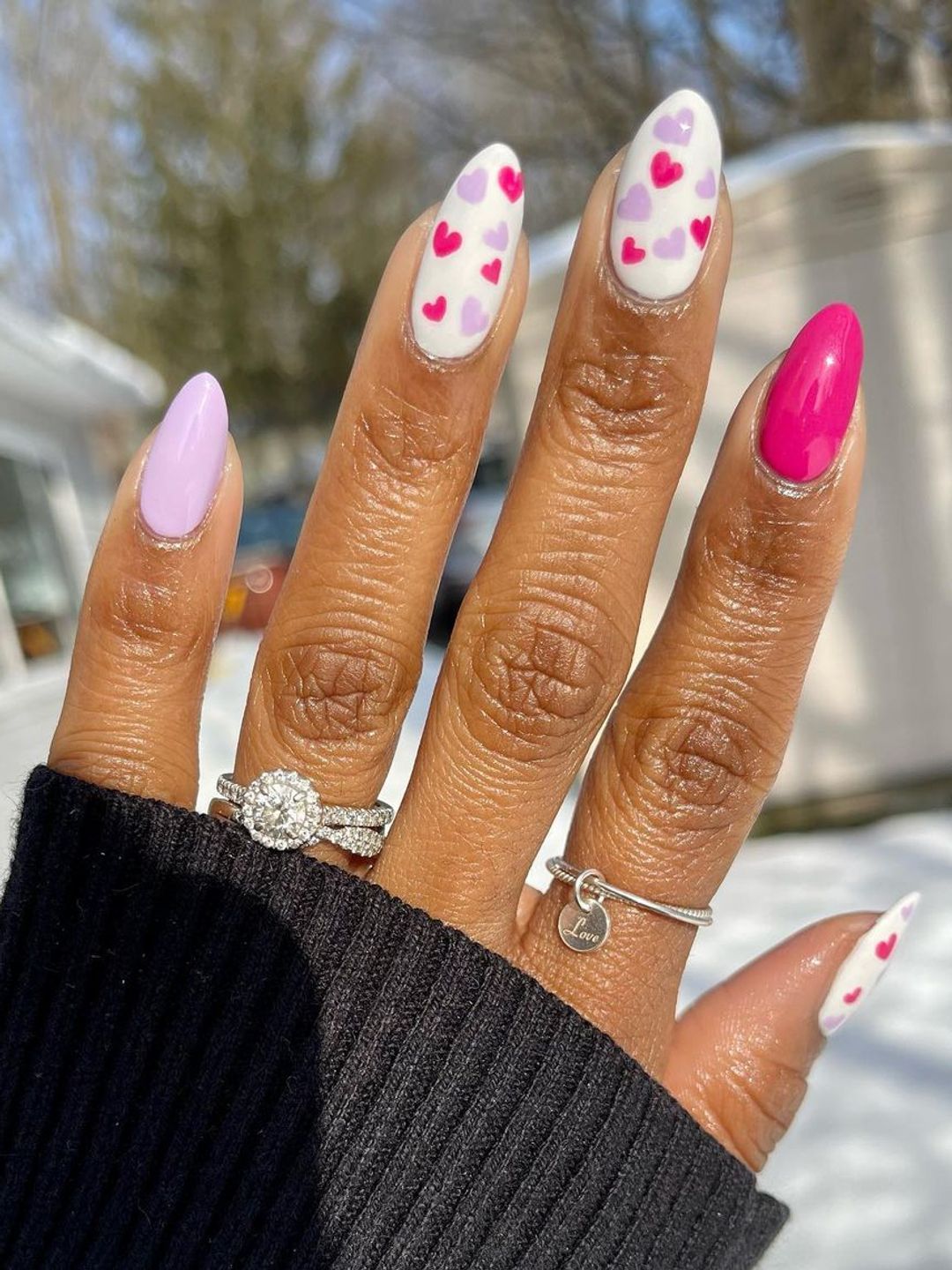 Nail look featuring multi-coloured hearts in lilac, white and pink 