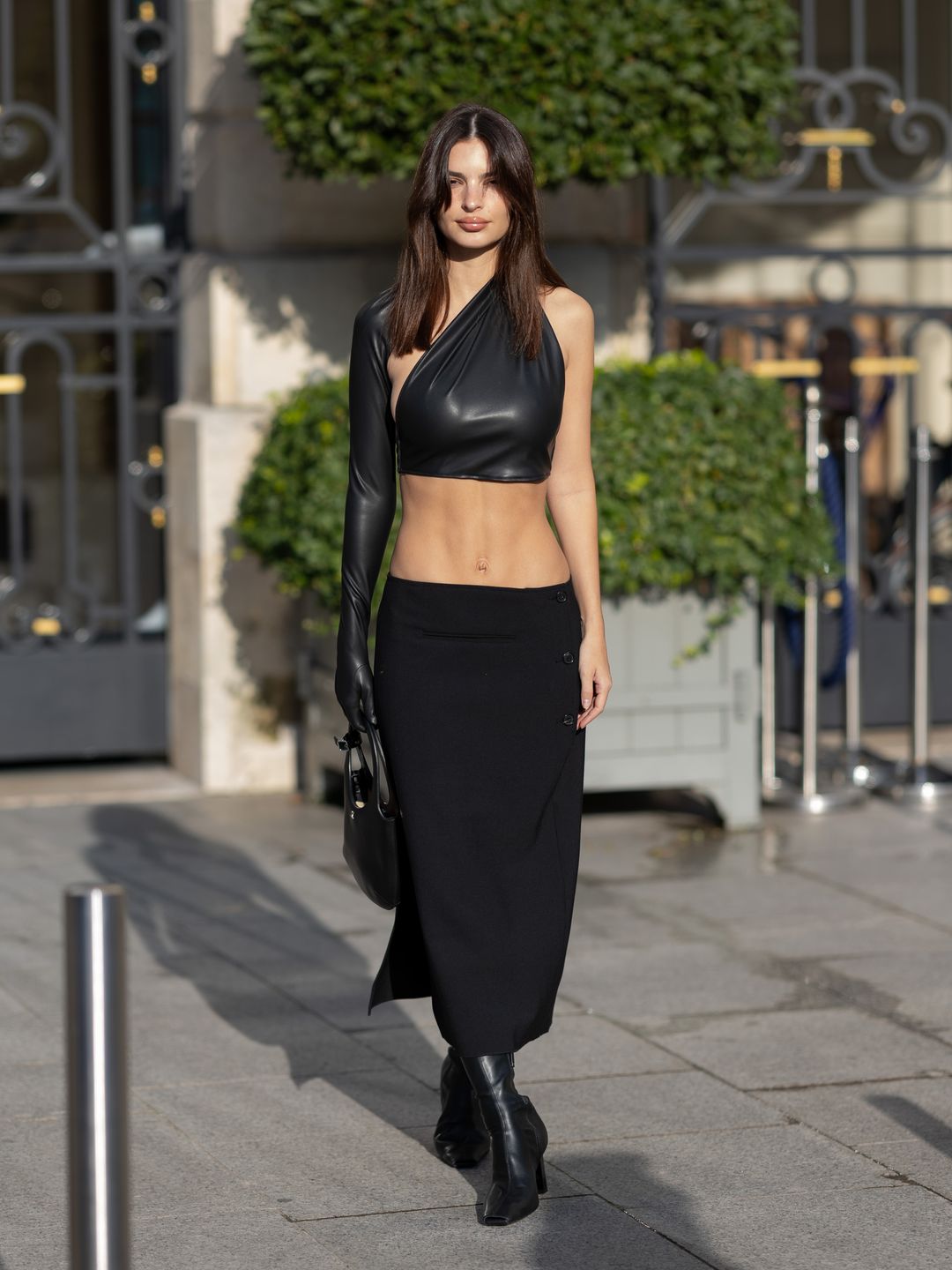 Emily Ratajkowski is seen heading to the Courreges show in a low rise black skirt and black crop top