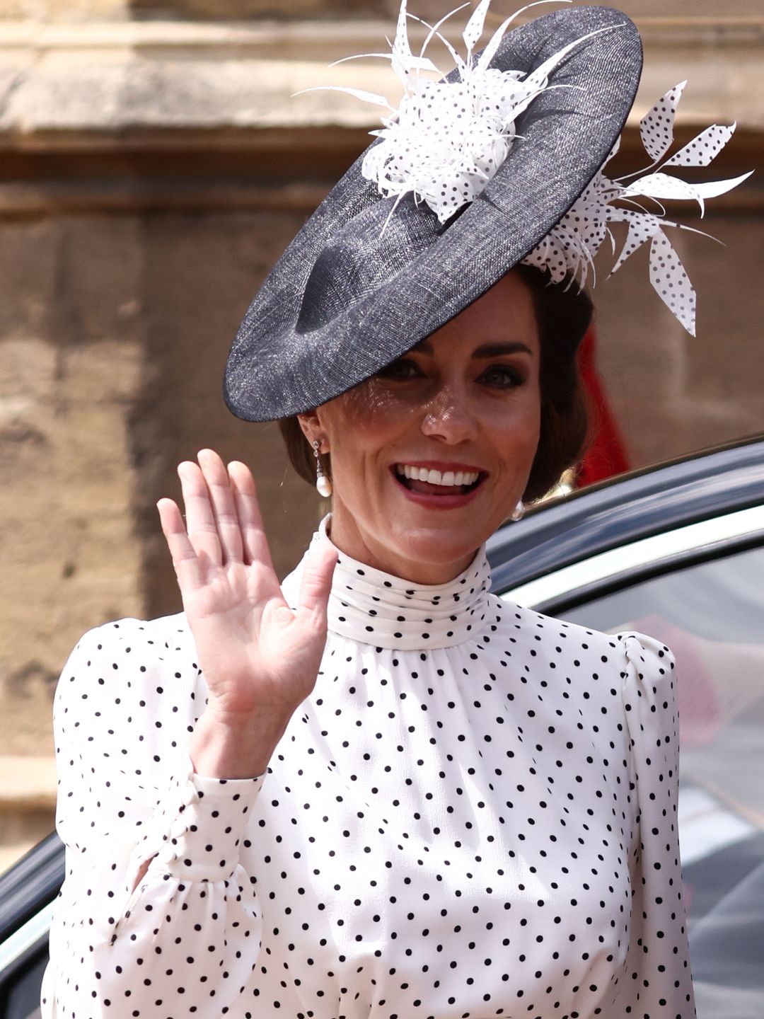 The Princess of Wales wearing a black and white polka dot dress and hat waving as she arrived at St George's Chapel to attend the Order Of The Garter Service 