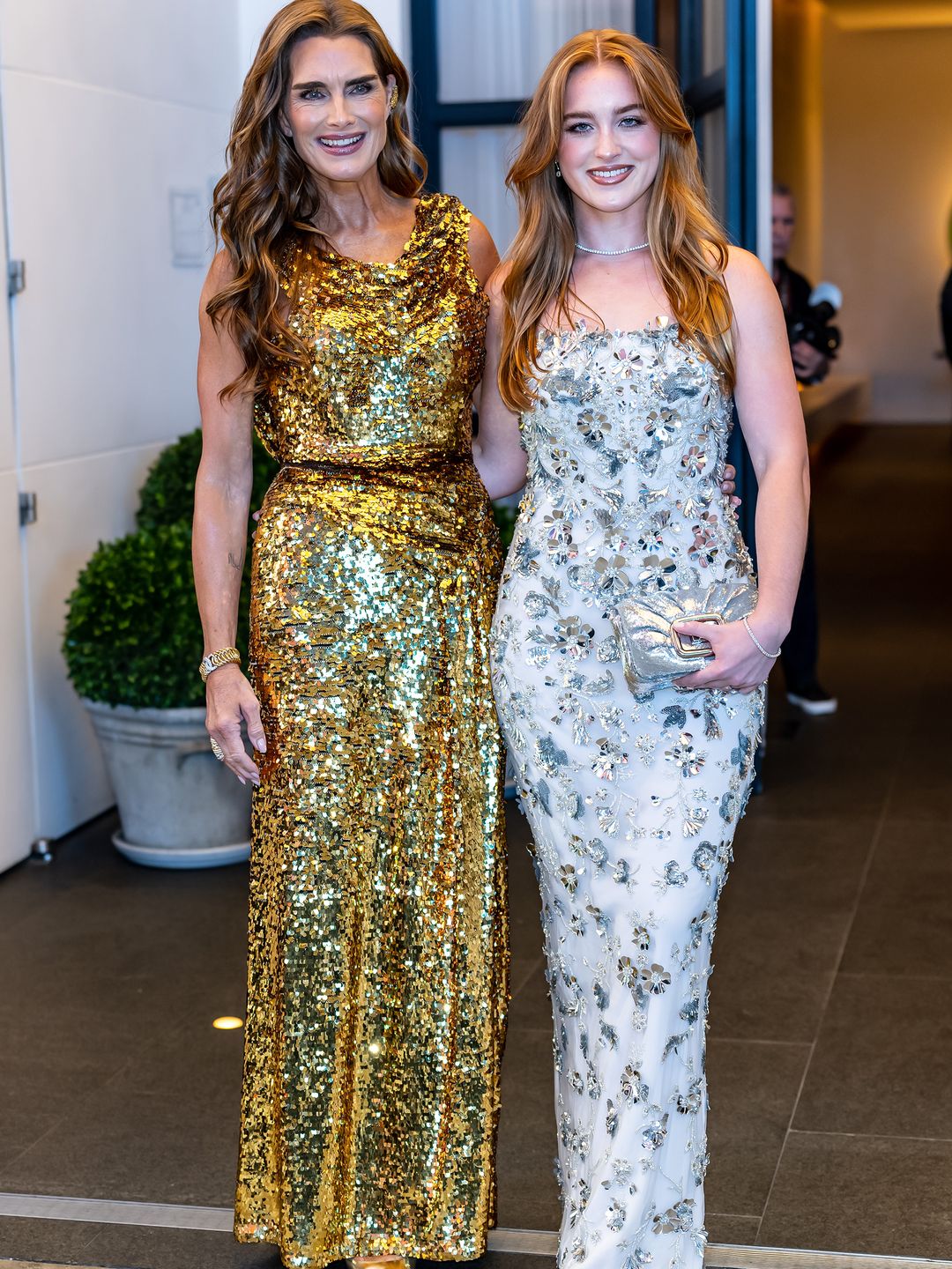 Brooke and her eldest daughter Rowan Francis at an event in New York earlier this year. Both are wearing sequin dresses, Brooke's is a floor length gold gown while Rowan's is a strapless silver dress with beaded detailing.