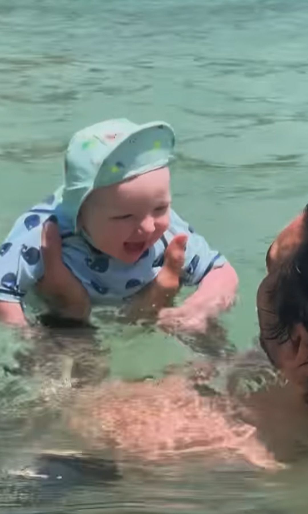 Adam Collard and a baby in a swimming pool