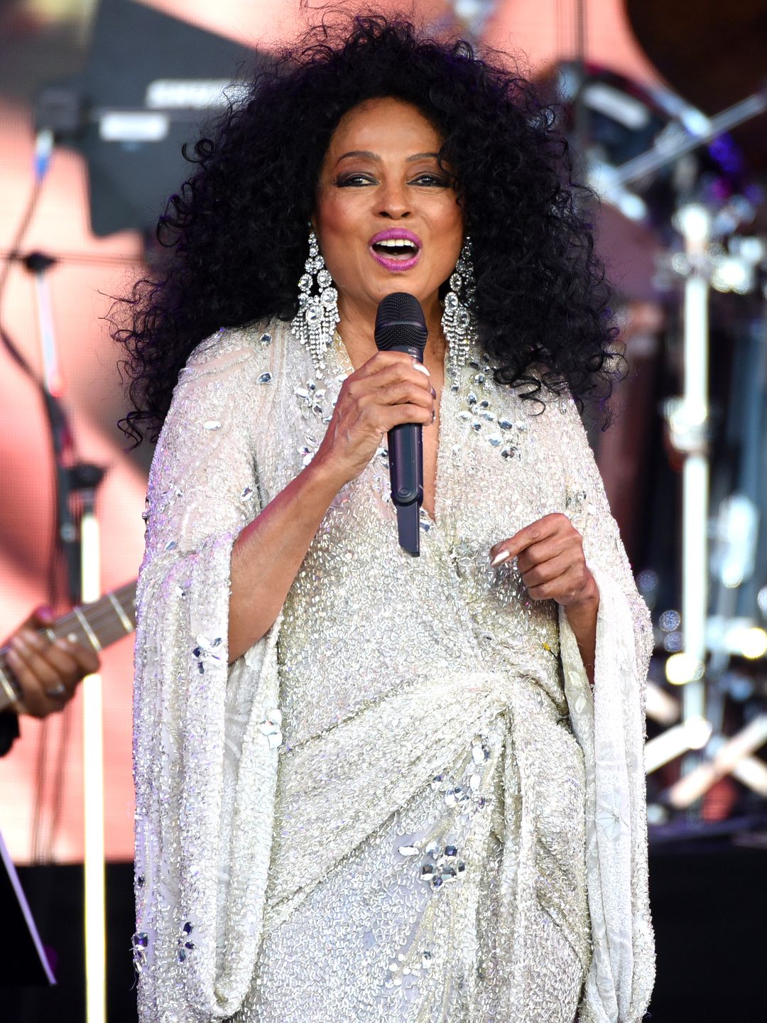 Diana Ross with sparkly earrings and bright pink lipstick 