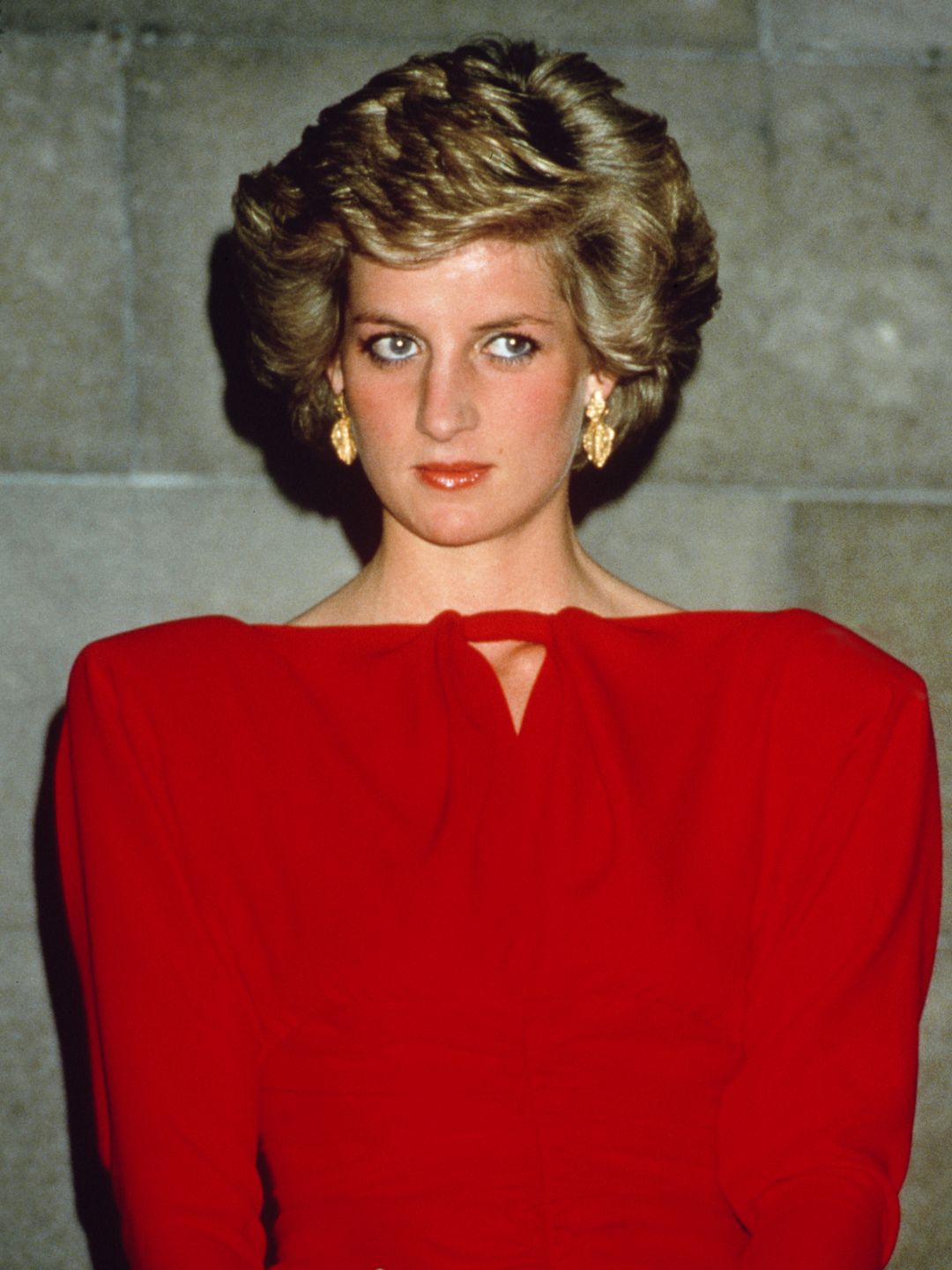 Princess Diana wearing a red shoulder pad dress